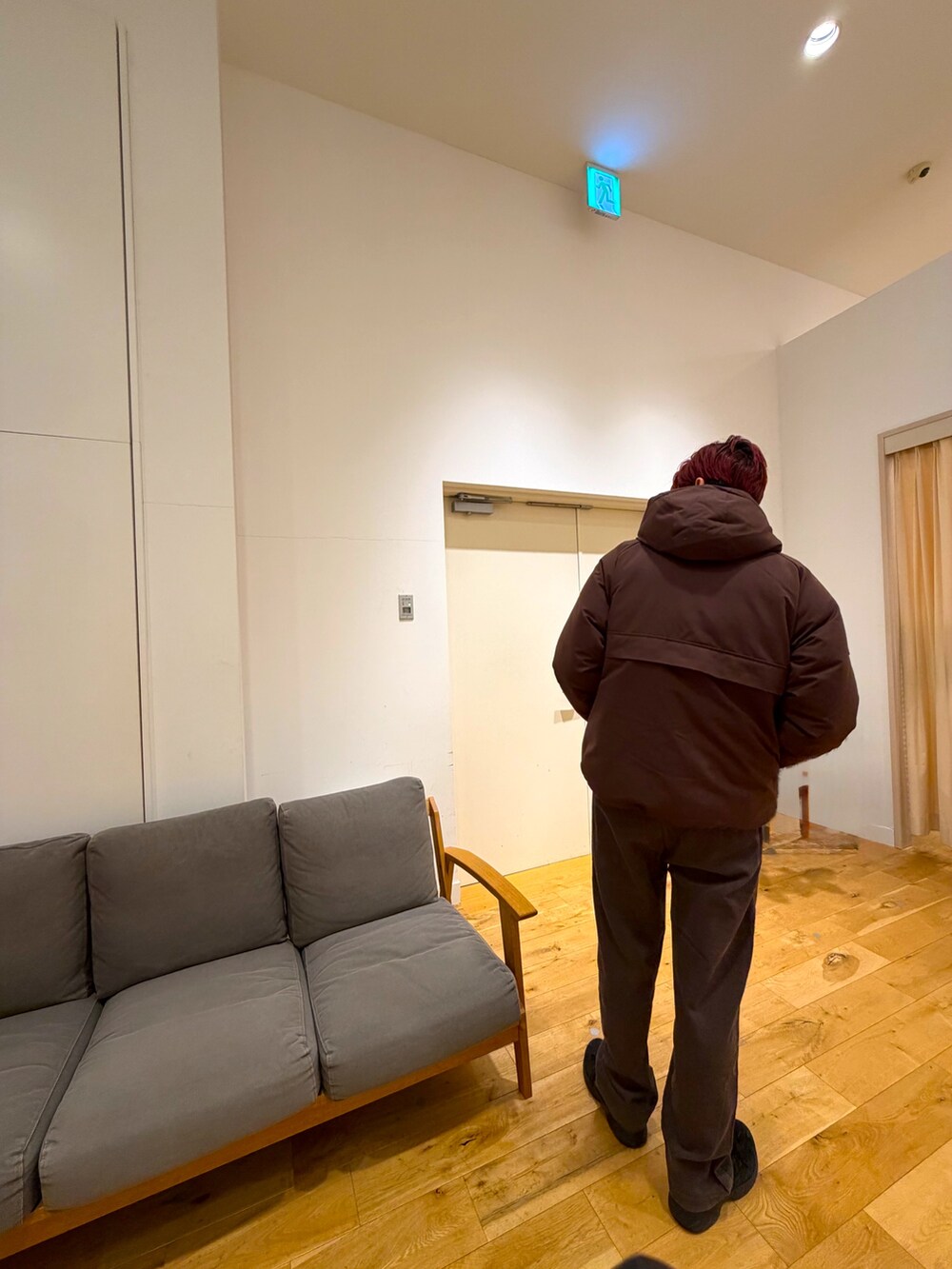 ブラウン系のジャケット/アウター、レッド系のニット/セーター、ブラウン系のその他パンツを着用したメンズの冬コーディネートの4枚目の写真