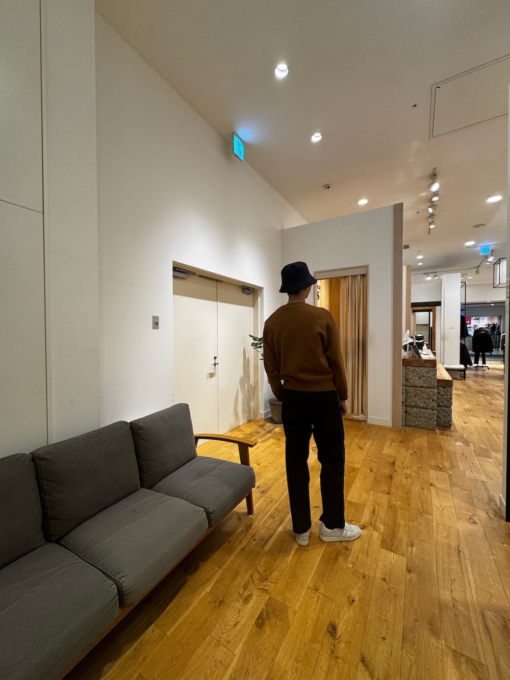 ブラウン系のニット/セーター、ブラック系のその他パンツ、ホワイト系のスニーカーを着用したメンズの秋コーディネートの2枚目の写真