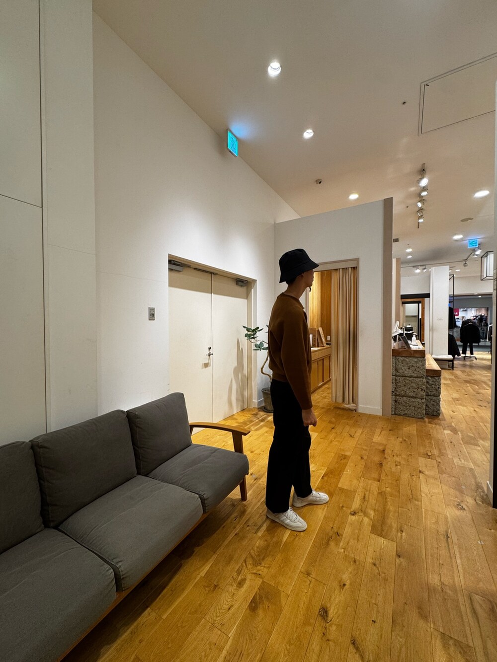 ブラウン系のニット/セーター、ブラック系のその他パンツ、ホワイト系のスニーカーを着用したメンズの秋コーディネートの4枚目の写真