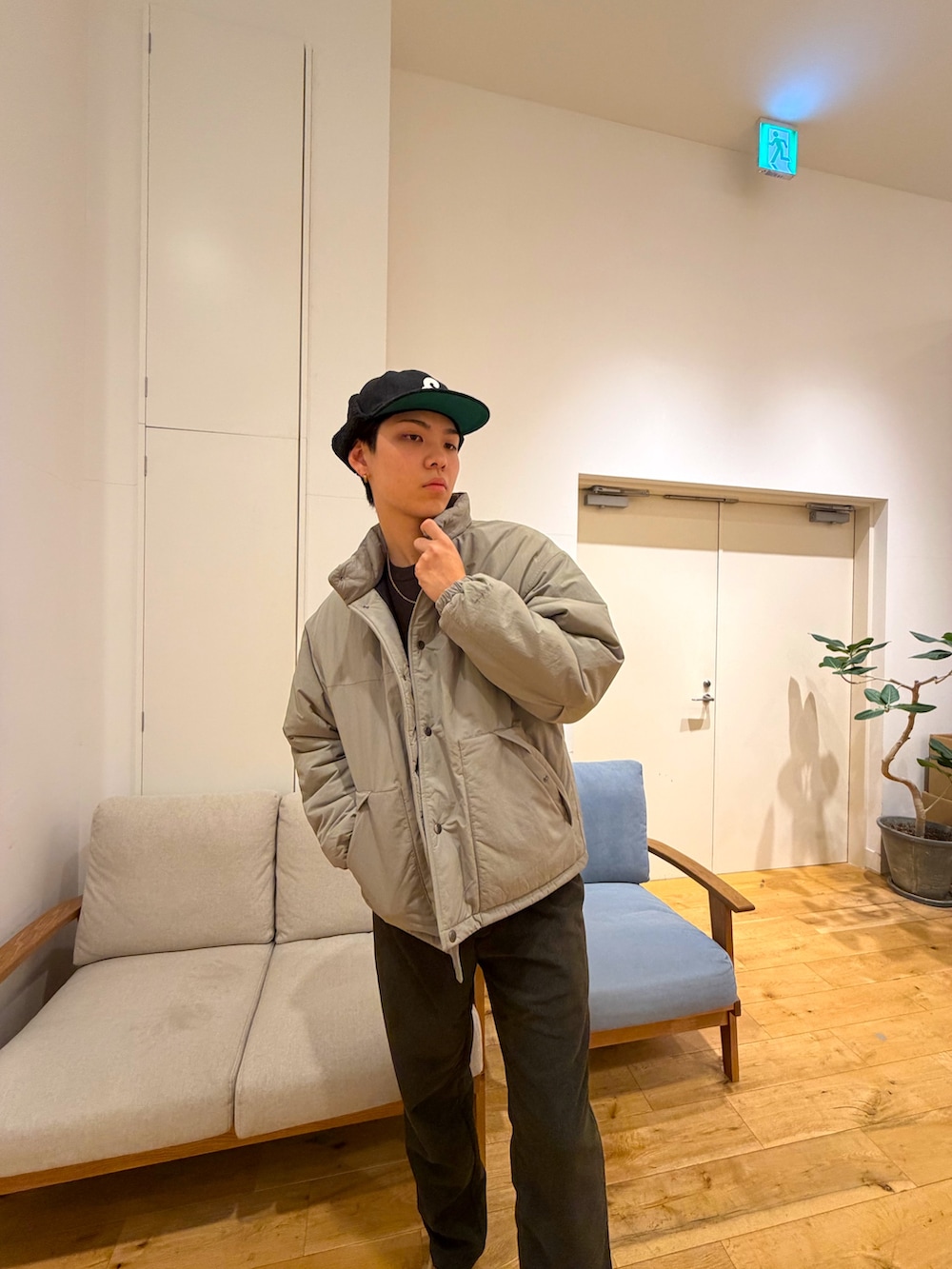 ベージュ系のダウンジャケット/コート、ブラウン系のニット/セーター、グリーン系のその他パンツを着用したメンズの冬コーディネートの5枚目の写真