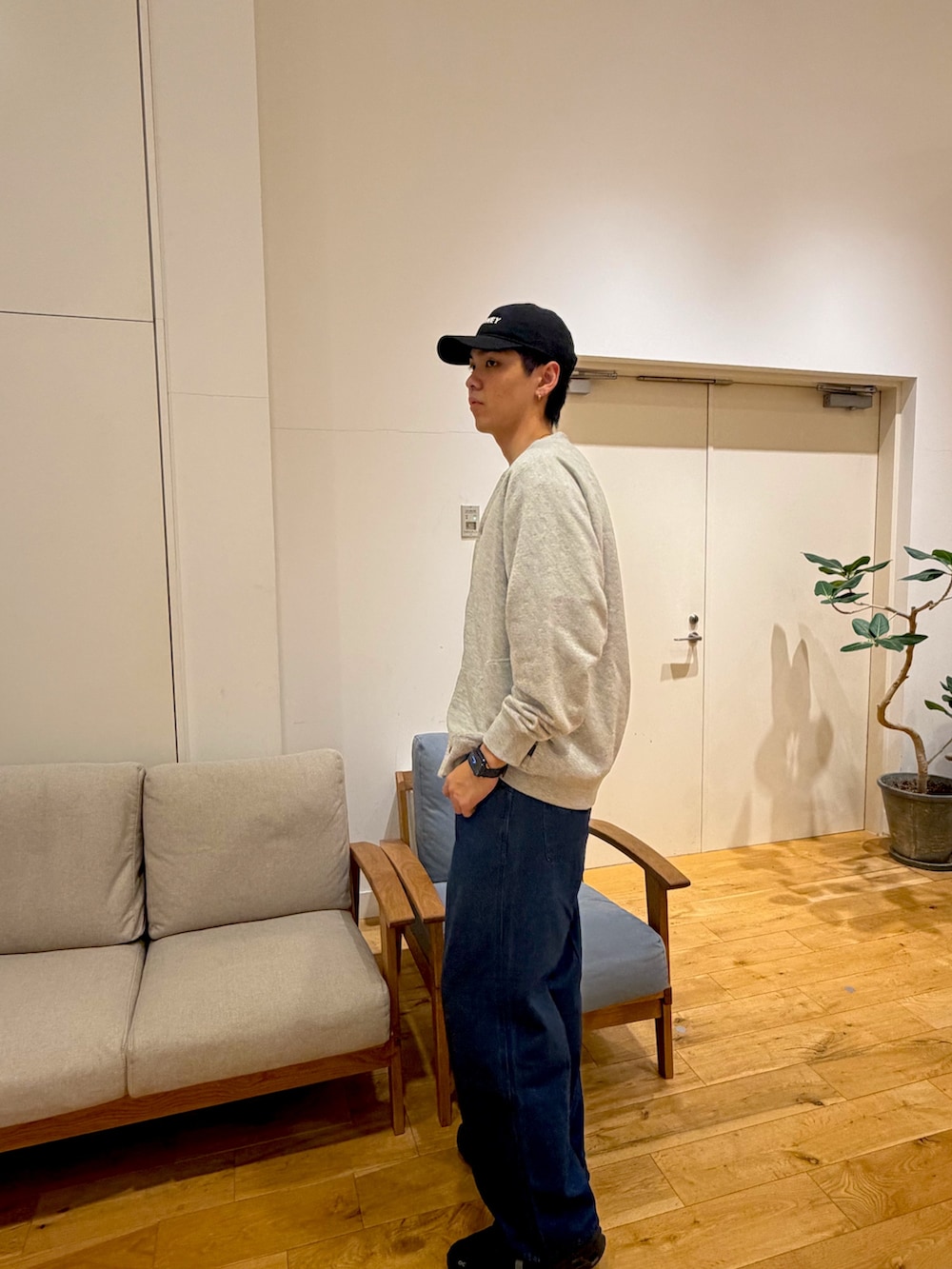 グレー系のカーディガン/ボレロ、ブルー系のデニムパンツ、ブラック系のスニーカーを着用したメンズの冬コーディネートの3枚目の写真