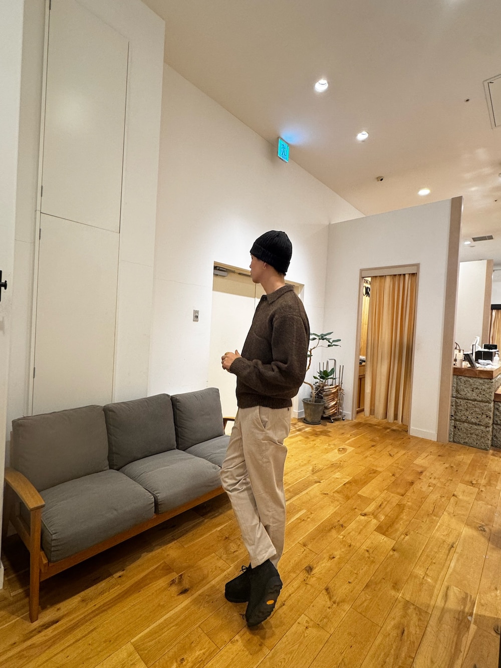 ブラウン系のニット/セーター、ホワイト系のその他パンツ、ブラック系のブーツを着用したメンズの秋コーディネートの2枚目の写真