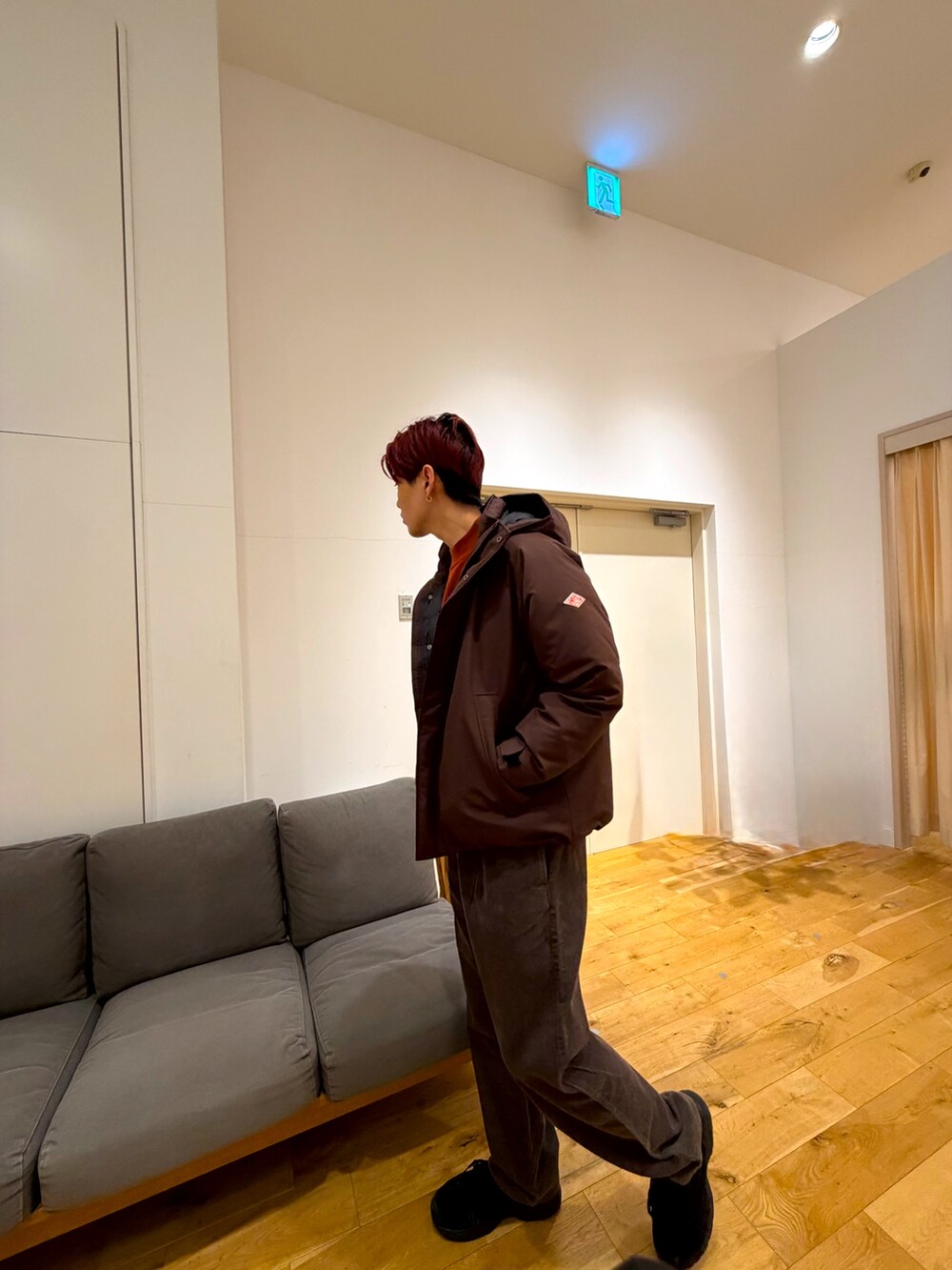 ブラウン系のジャケット/アウター、レッド系のニット/セーター、ブラウン系のその他パンツを着用したメンズの冬コーディネートの3枚目の写真