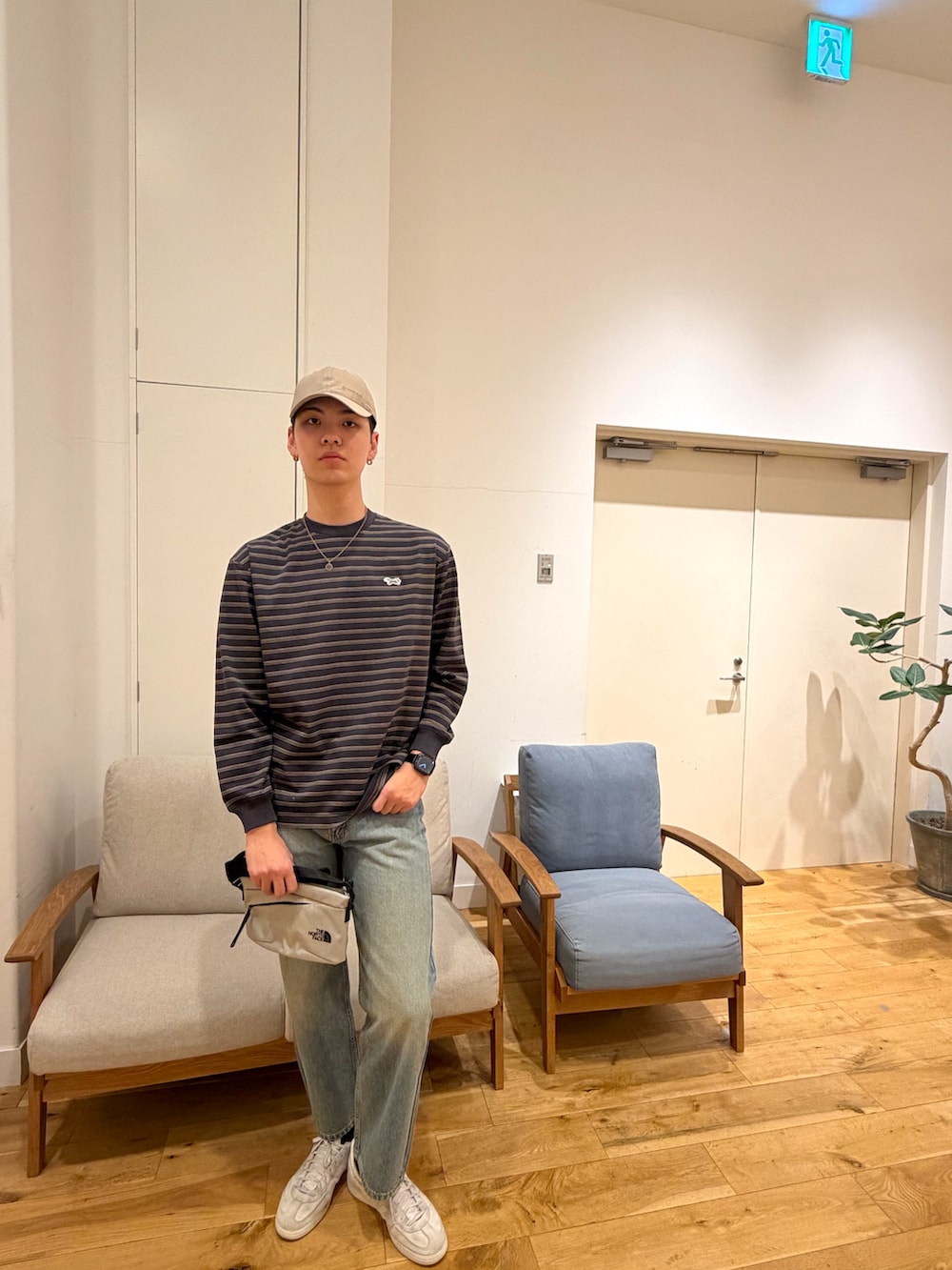 ブラック系のTシャツ/カットソー、ブラック系のデニムパンツ、ホワイト系のスニーカーを着用したメンズの冬コーディネートの4枚目の写真