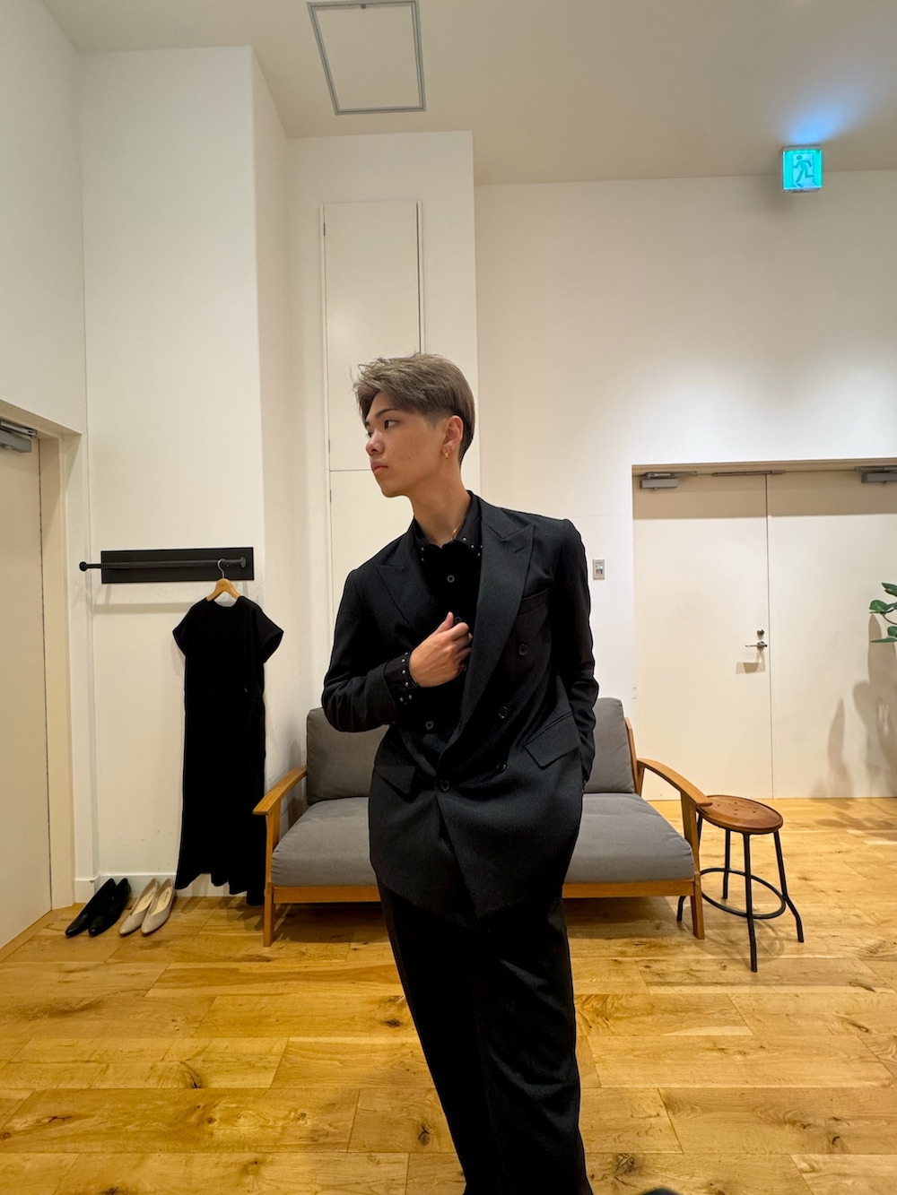 ブラック系のスーツジャケット、ブラック系のスニーカー、ブラック系のスーツパンツを着用したメンズの秋コーディネートの2枚目の写真