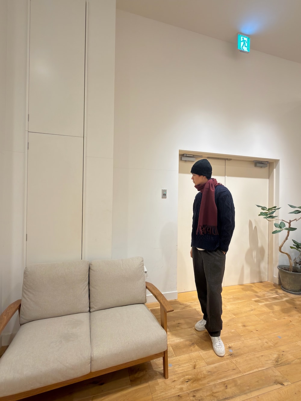 ブルー系のニット/セーター、グレー系のその他パンツ、ホワイト系のスニーカーを着用したメンズの冬コーディネートの3枚目の写真