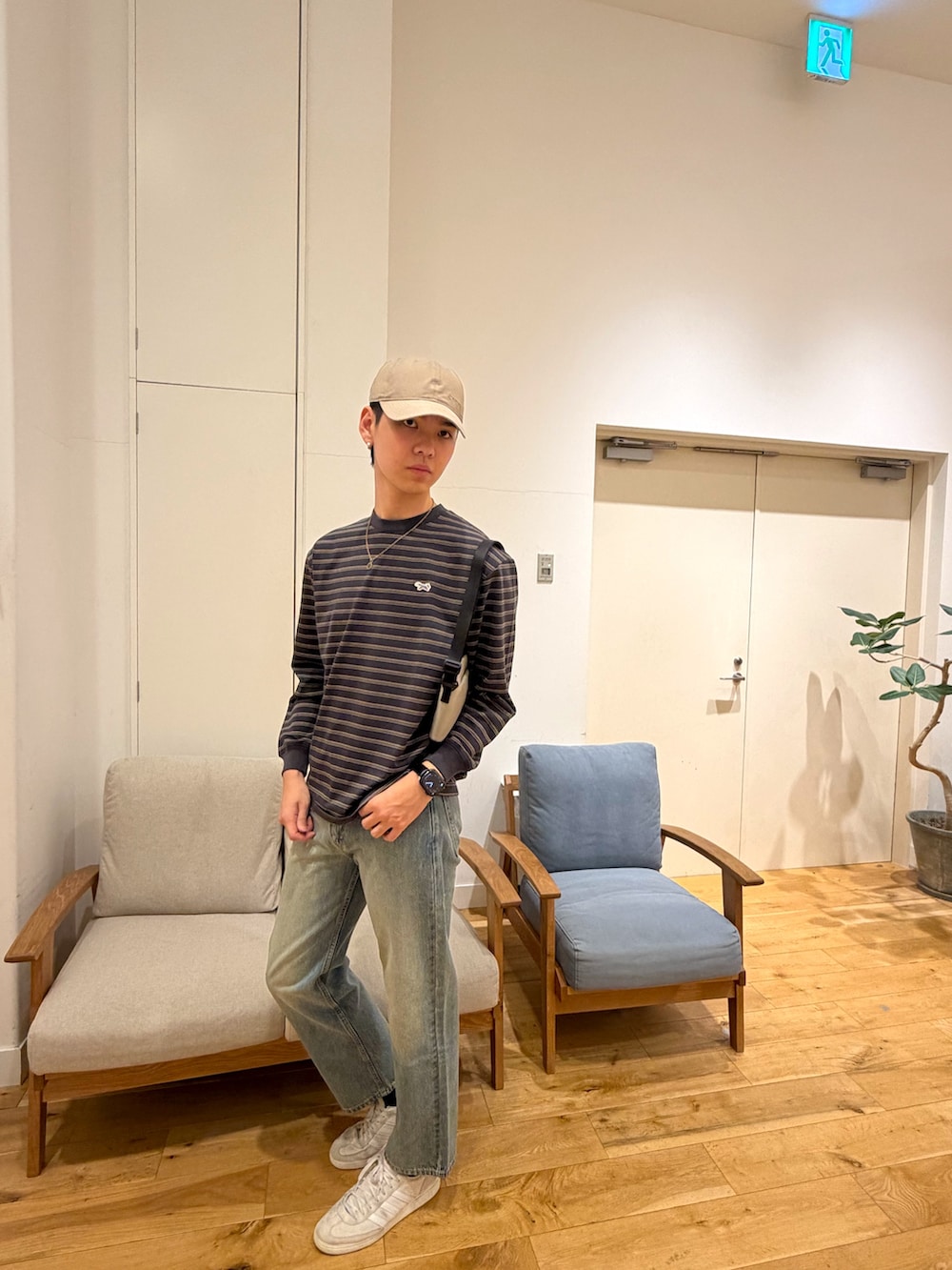 ブラック系のTシャツ/カットソー、ブラック系のデニムパンツ、ホワイト系のスニーカーを着用したメンズの冬コーディネートの2枚目の写真