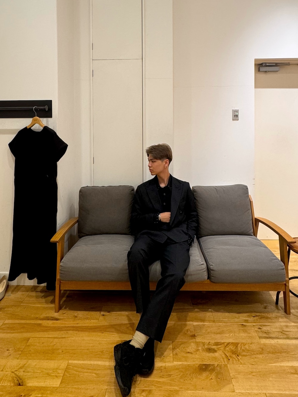 ブラック系のスーツジャケット、ブラック系のスニーカー、ブラック系のスーツパンツを着用したメンズの秋コーディネートの4枚目の写真