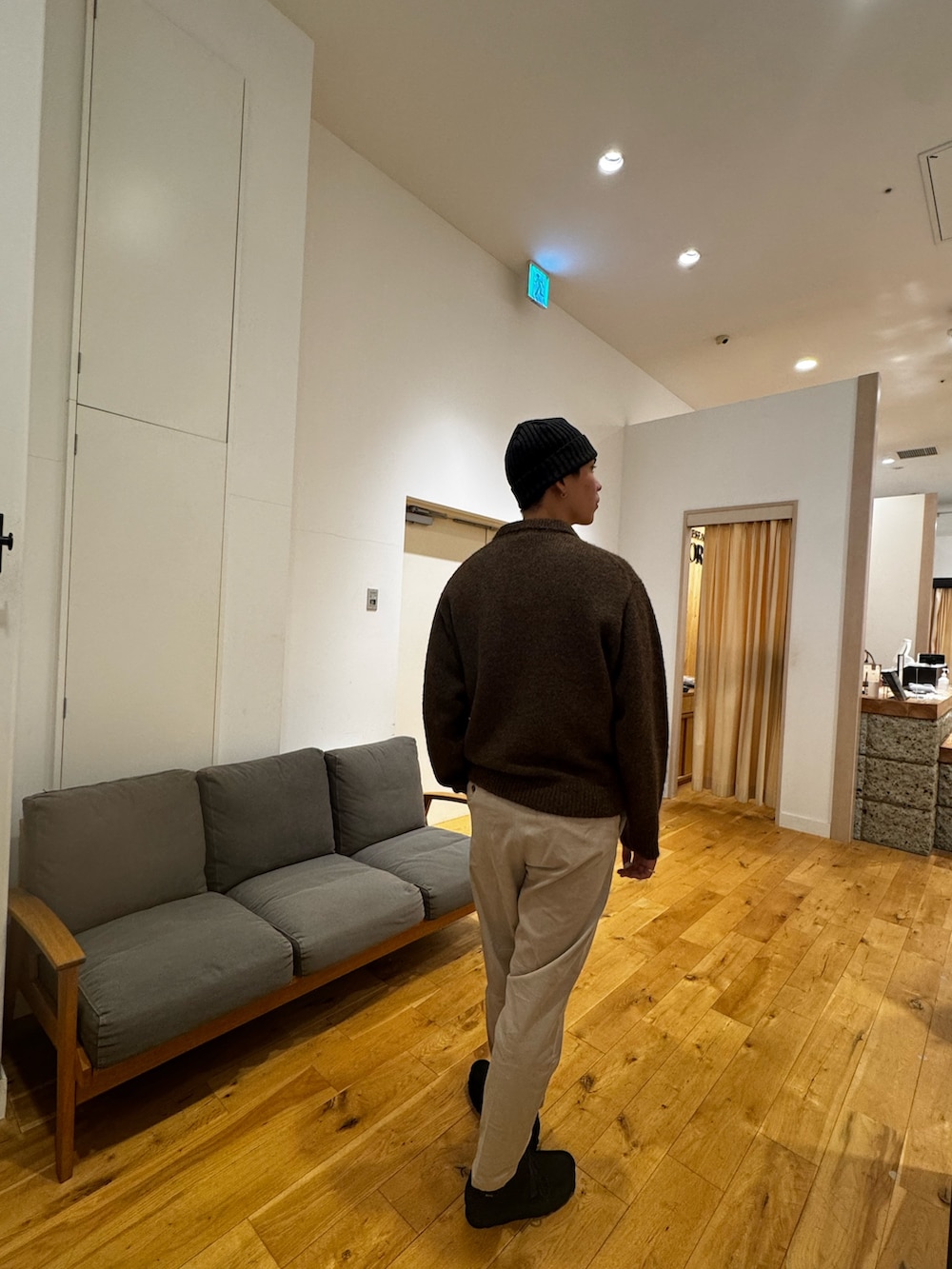 ブラウン系のニット/セーター、ホワイト系のその他パンツ、ブラック系のブーツを着用したメンズの秋コーディネートの3枚目の写真