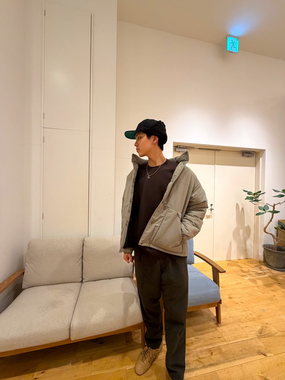 ベージュ系のダウンジャケット/コート、ブラウン系のニット/セーター、グリーン系のその他パンツを着用したメンズの冬コーディネートの2枚目の写真