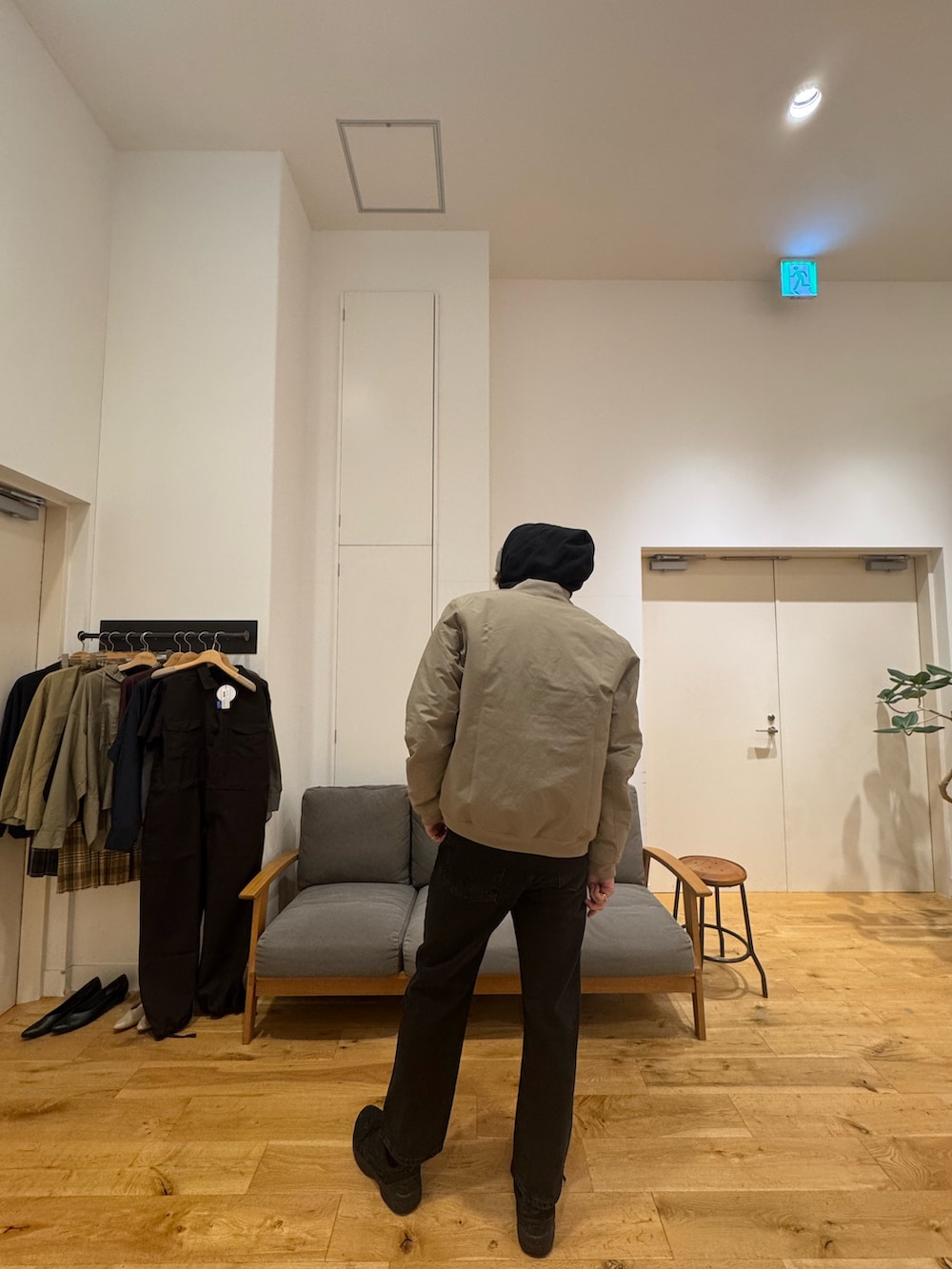 ベージュ系のジャケット/アウター、ブラック系のパーカー、ブラック系のデニムパンツを着用したメンズの秋コーディネートの2枚目の写真