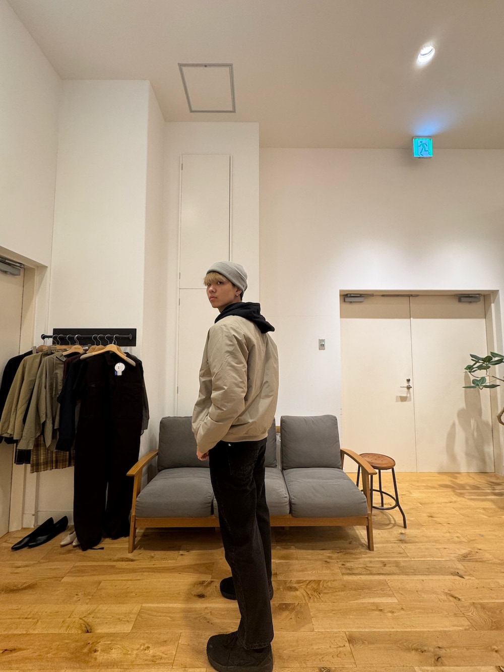 ベージュ系のジャケット/アウター、ブラック系のパーカー、ブラック系のデニムパンツを着用したメンズの秋コーディネートの4枚目の写真