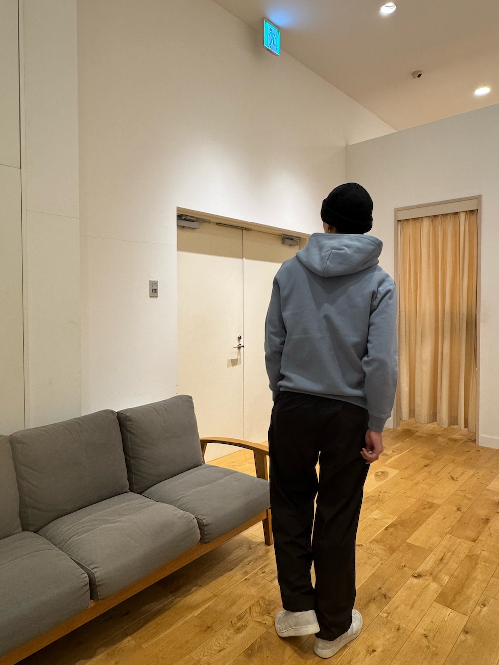 ブルー系のパーカー、ブラック系のその他パンツ、ホワイト系のスニーカーを着用したメンズの秋コーディネートの4枚目の写真