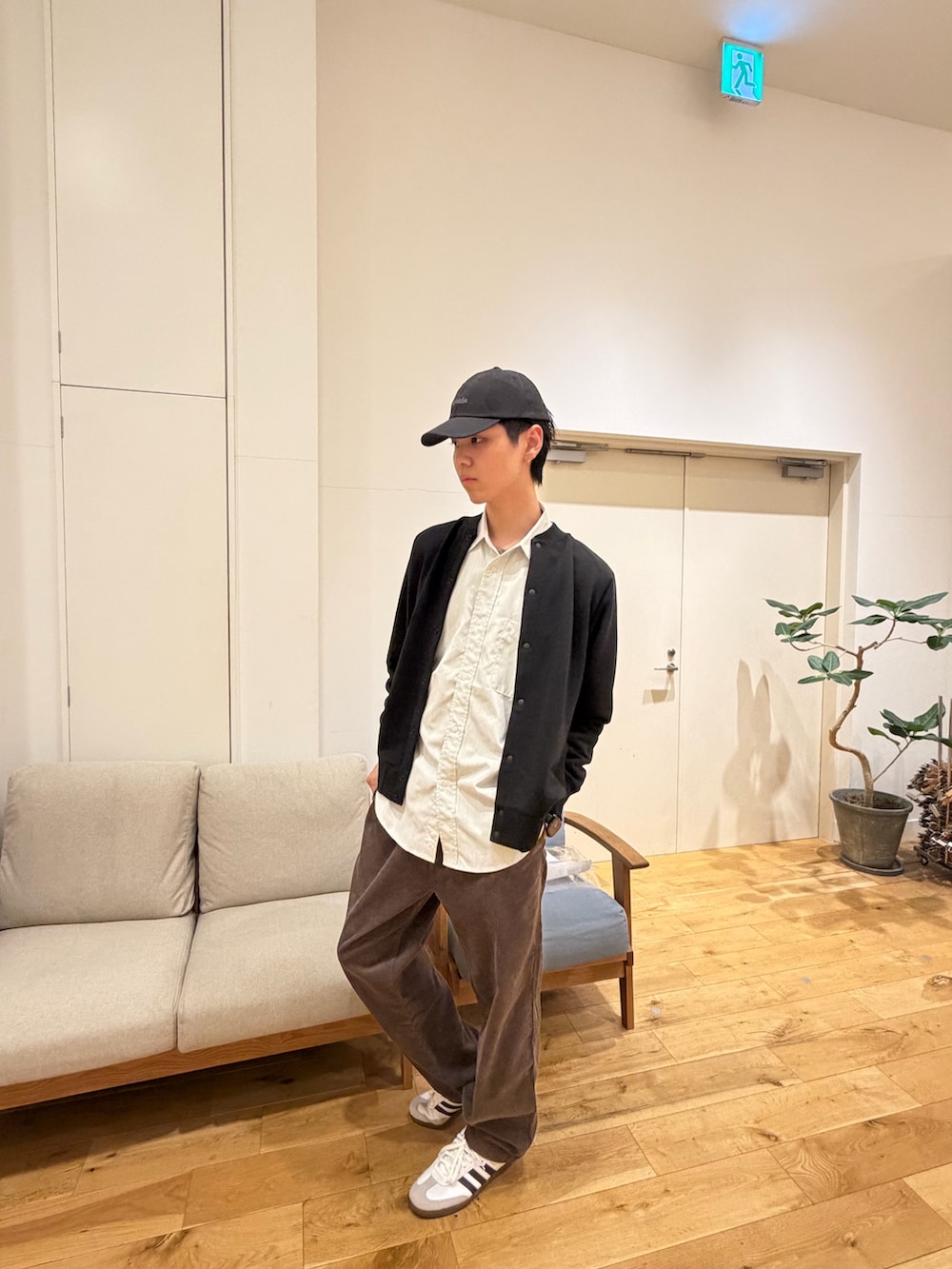 ブラック系のカーディガン/ボレロ、ホワイト系のシャツ/ブラウス、ホワイト系のスニーカーを着用したメンズの冬コーディネートの4枚目の写真