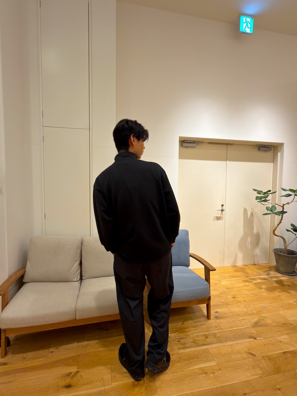 ブラック系のスウェット、ブルー系のその他パンツ、ブラック系のスニーカーを着用したメンズの冬コーディネートの2枚目の写真