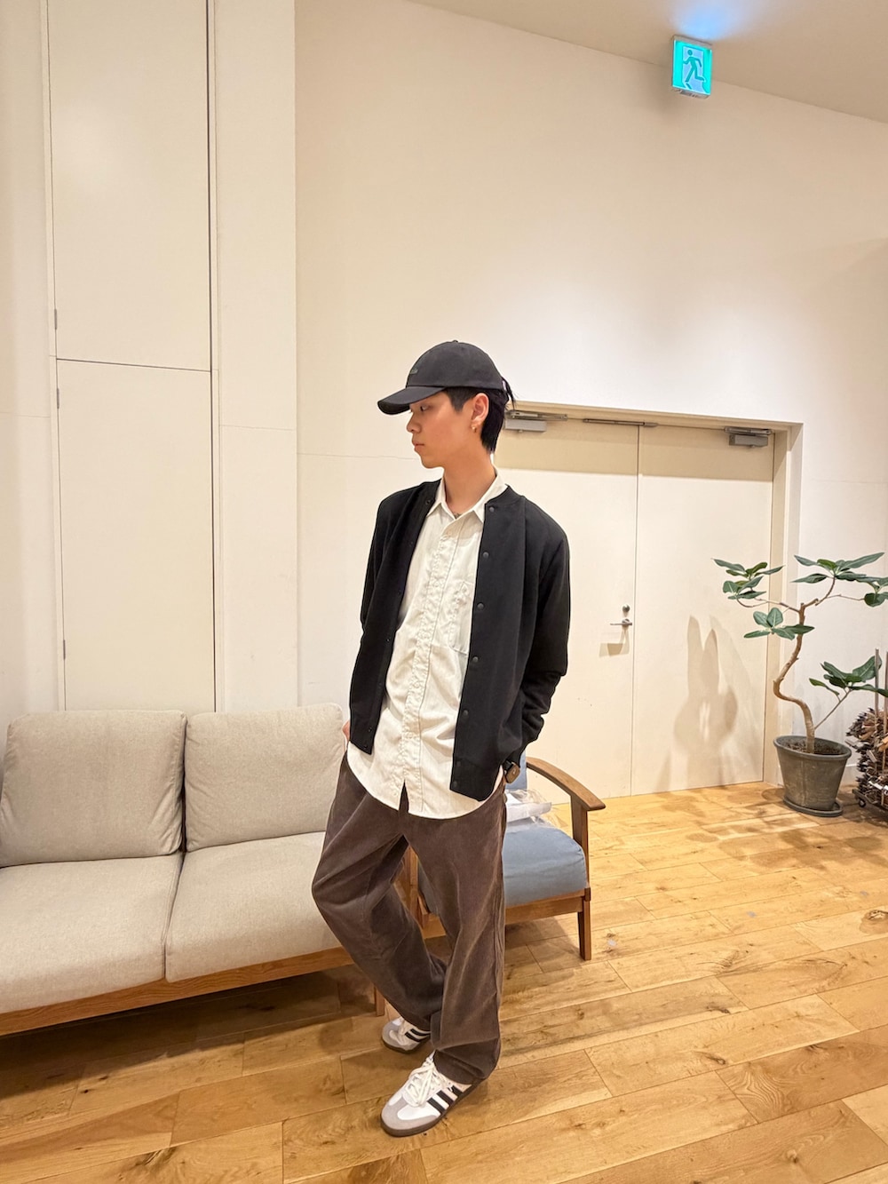 ブラック系のカーディガン/ボレロ、ホワイト系のシャツ/ブラウス、ホワイト系のスニーカーを着用したメンズの冬コーディネートの2枚目の写真