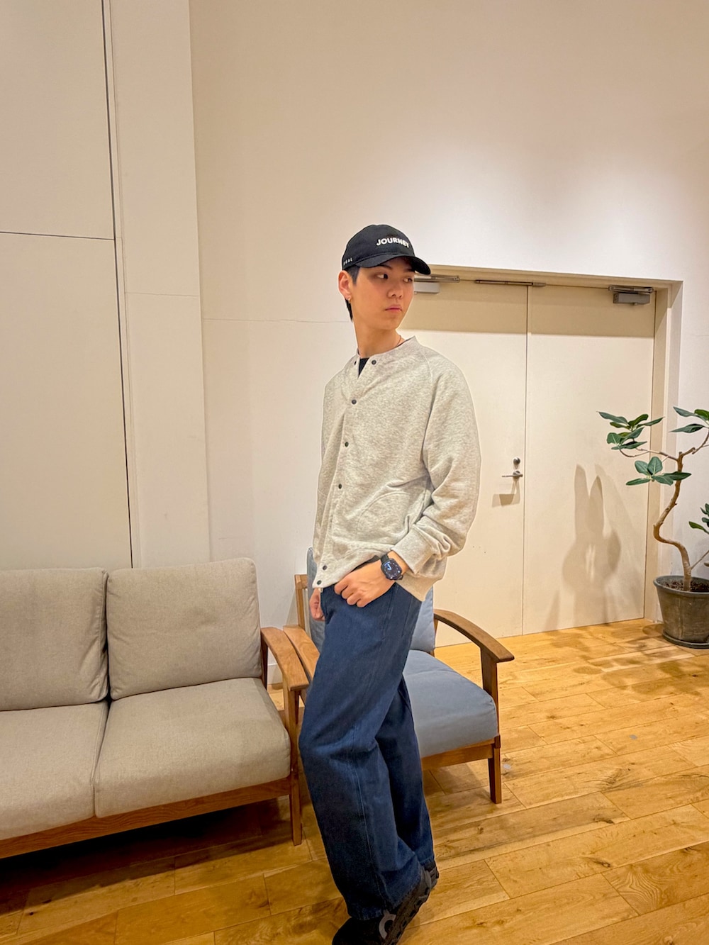 グレー系のカーディガン/ボレロ、ブルー系のデニムパンツ、ブラック系のスニーカーを着用したメンズの冬コーディネートの4枚目の写真