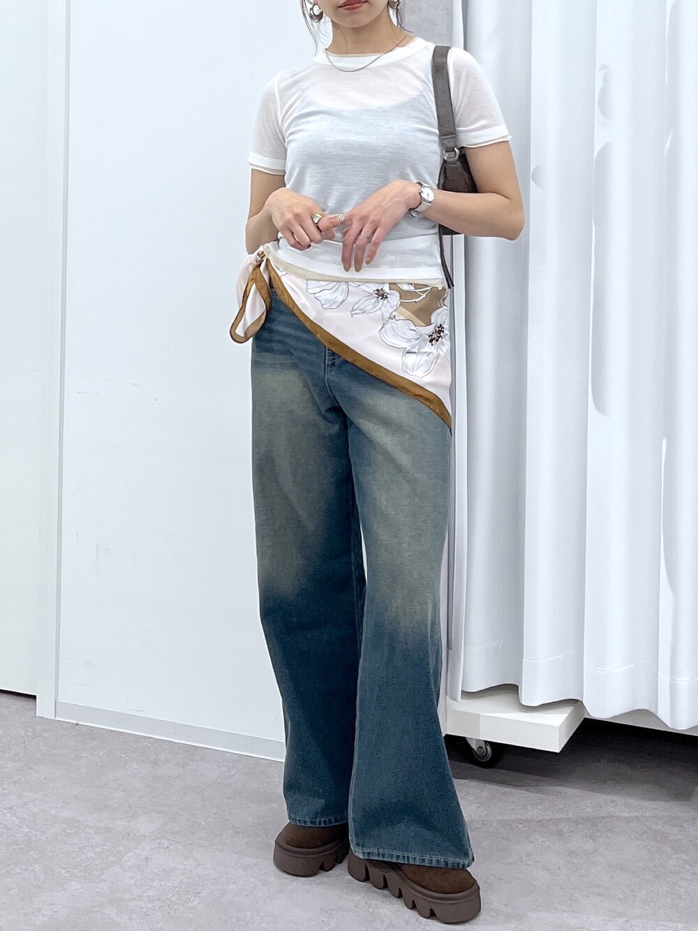ホワイト系のTシャツ/カットソー、ブラウン系のショルダーバッグ、ブルー系のデニムパンツを着用したレディースの春コーディネートの5枚目の写真