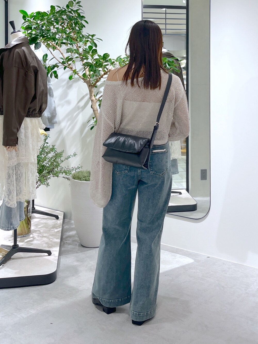 ホワイト系のニット/セーター、ホワイト系のキャミソール、ブラック系のショルダーバッグを着用したレディースの春コーディネートの7枚目の写真