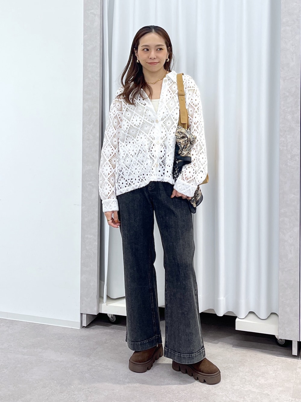 ホワイト系のブルゾン、ブラウン系のショルダーバッグ、ブラック系のデニムパンツを着用したレディースの春コーディネートの8枚目の写真