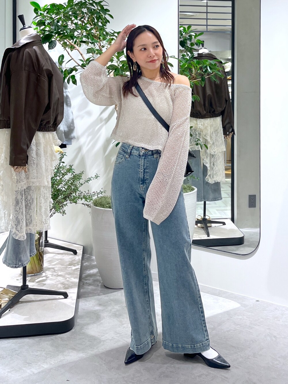 ホワイト系のニット/セーター、ホワイト系のキャミソール、ブラック系のショルダーバッグを着用したレディースの春コーディネートの9枚目の写真