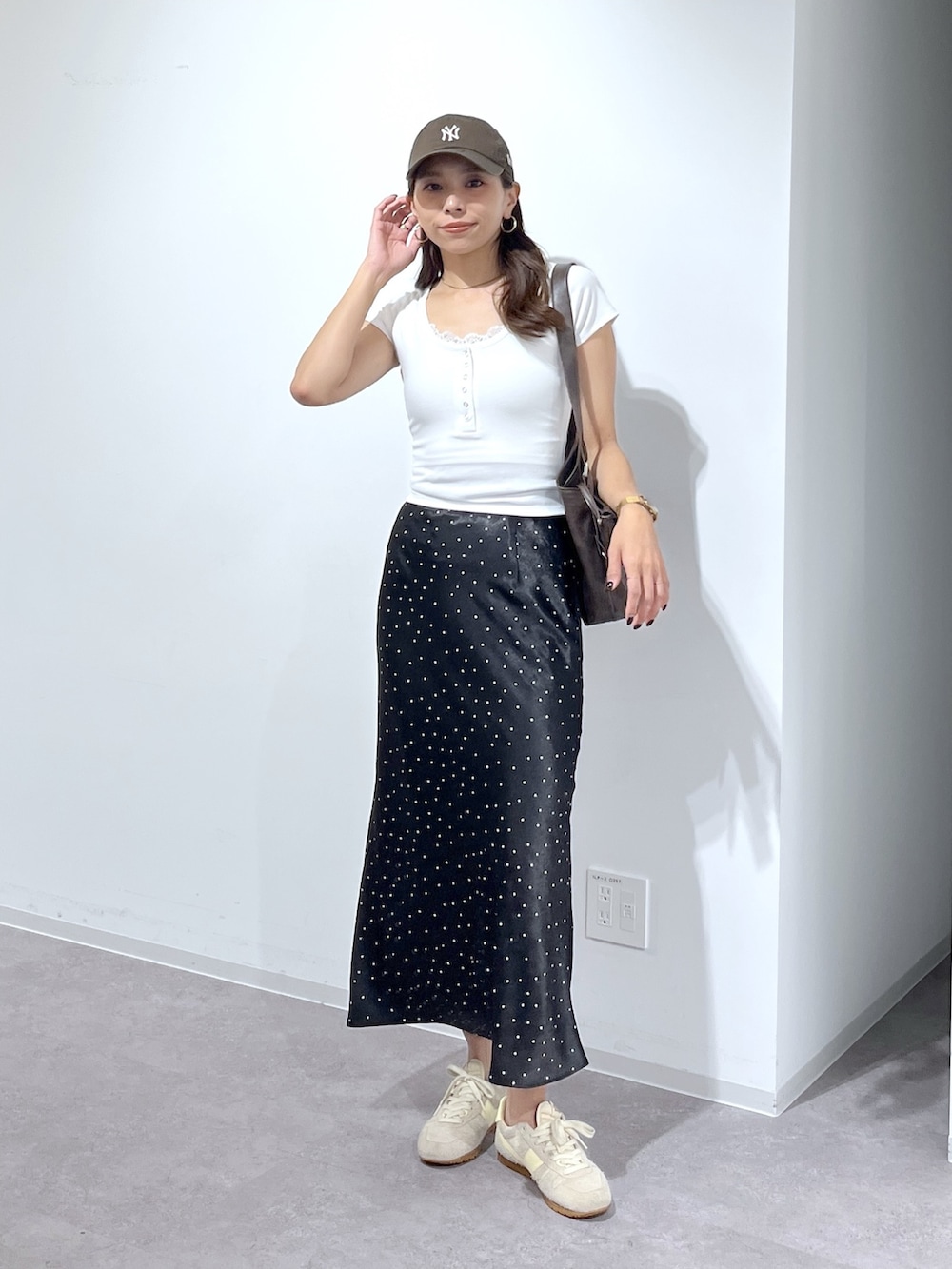 ホワイト系のTシャツ/カットソー、ブラウン系のショルダーバッグ、ブラック系のスカートを着用したレディースの夏コーディネートの3枚目の写真