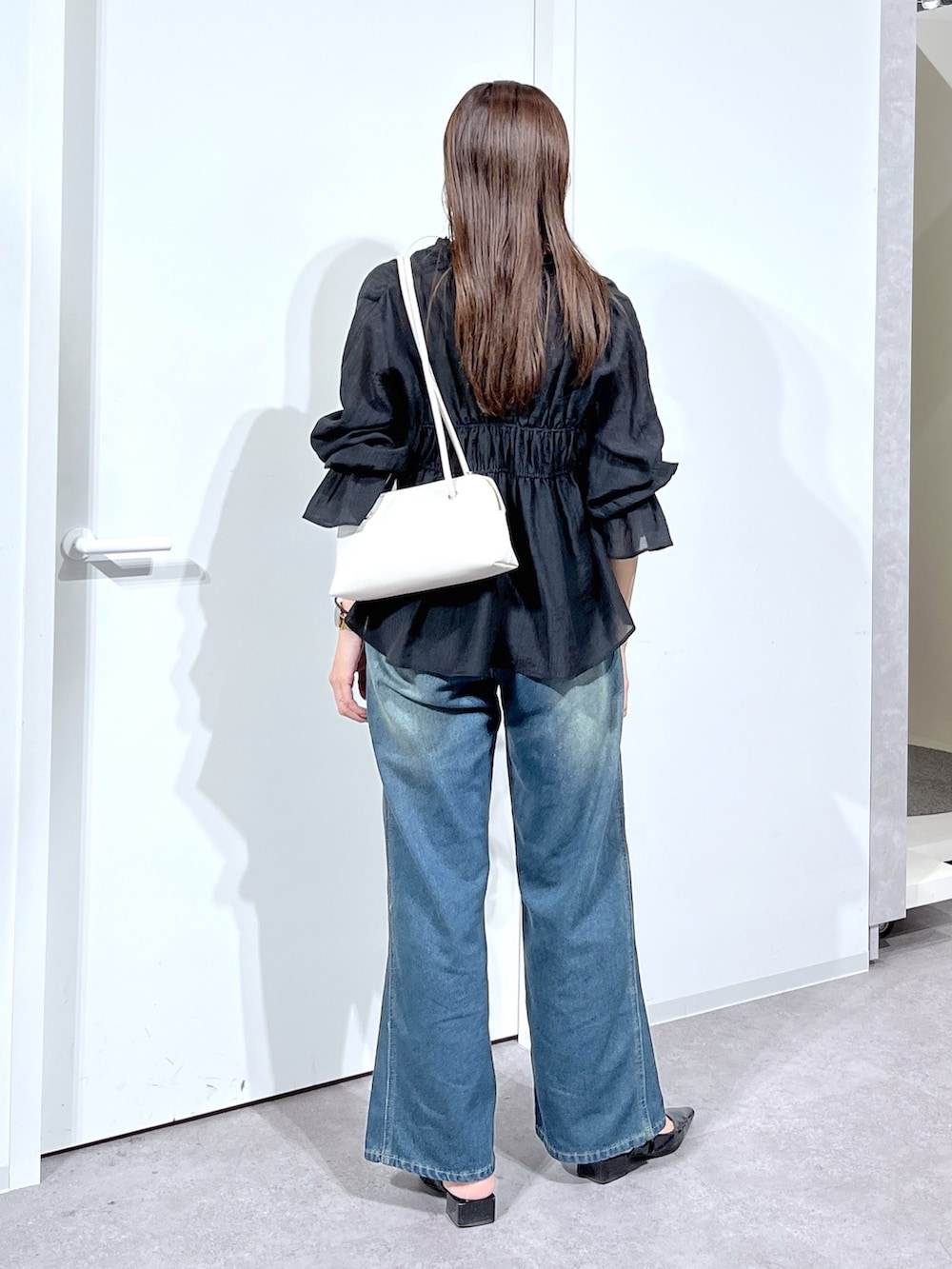 ブラック系のシャツ/ブラウス、ブルー系のデニムパンツを着用したレディースの春コーディネートの5枚目の写真