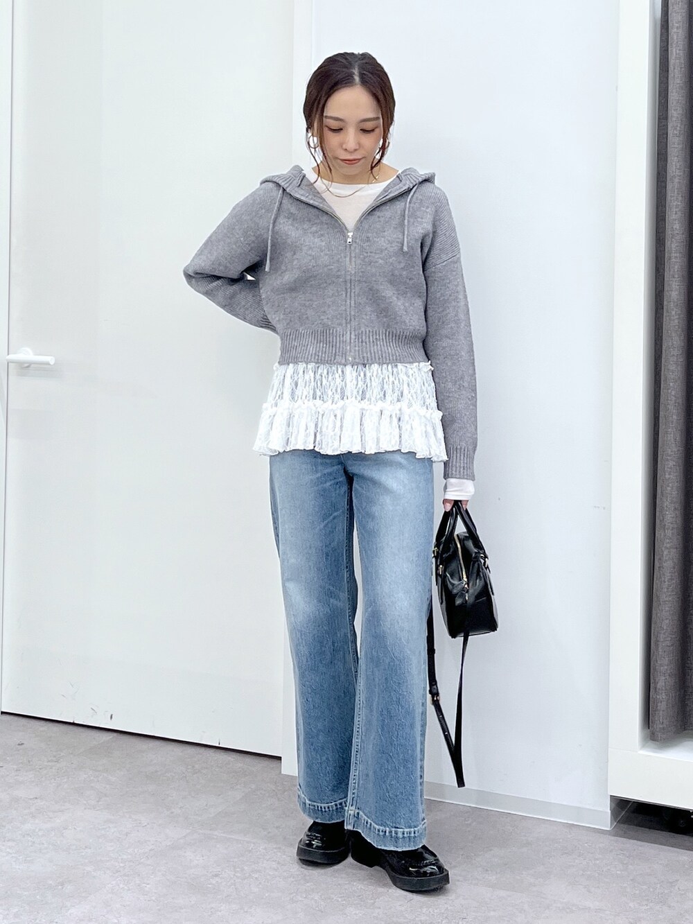 ブラック系のショルダーバッグ、ブルー系のデニムパンツ、ホワイト系のTシャツ/カットソーを着用したレディースの冬コーディネートの4枚目の写真