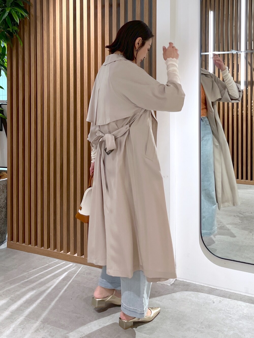 ブラウン系のショルダーバッグ、ホワイト系のTシャツ/カットソー、オレンジ系のベストを着用したレディースの春コーディネートの6枚目の写真