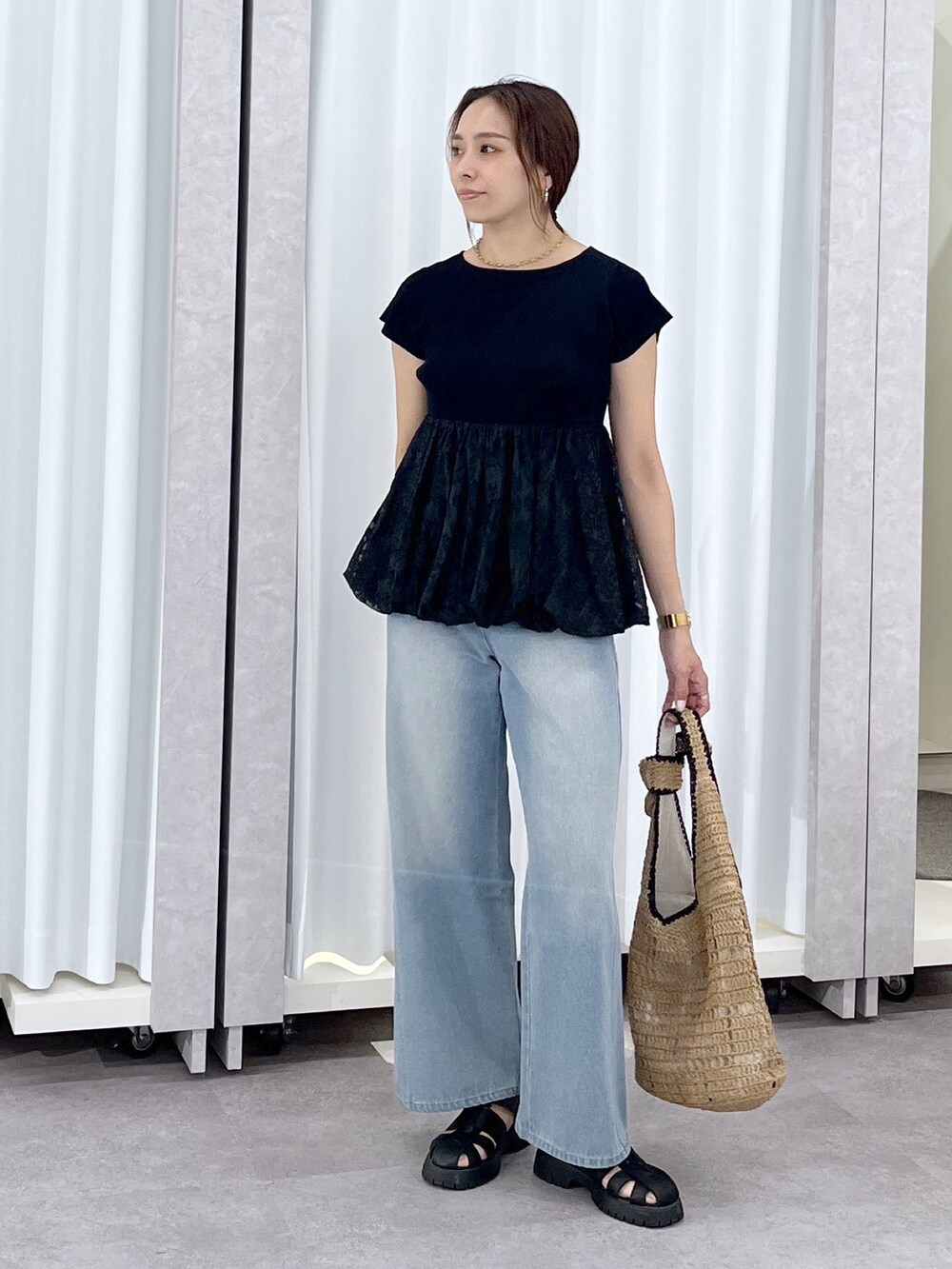 ブルー系のデニムパンツ、ブラック系のニット/セーターを着用したレディースの春コーディネートの8枚目の写真