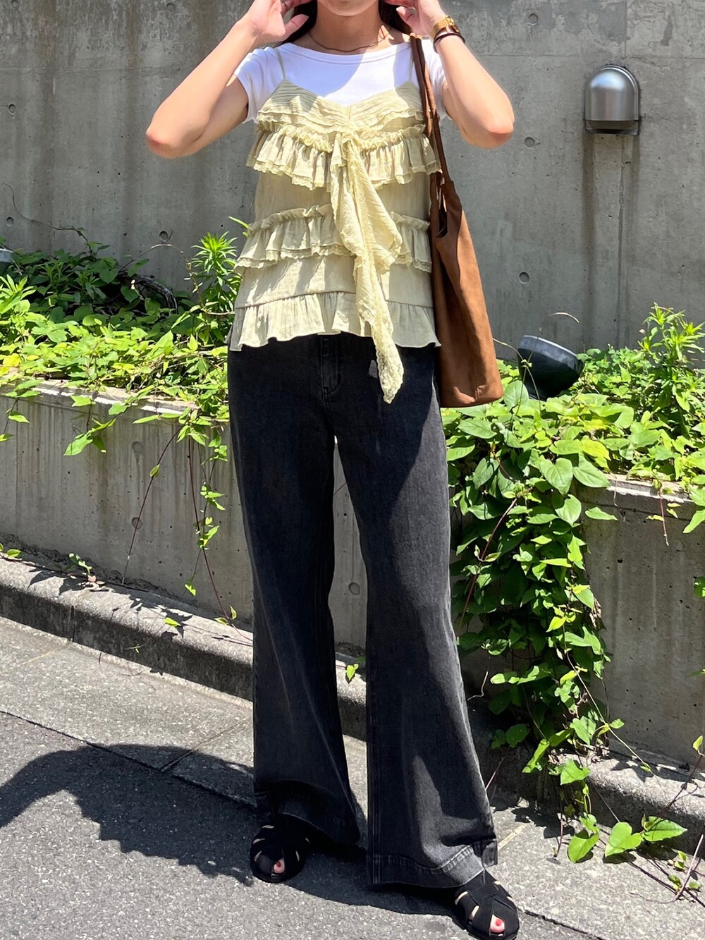 イエロー系のシャツ/ブラウス、ブラック系のデニムパンツ、ブラック系のサンダルを着用したレディースの夏コーディネートの5枚目の写真