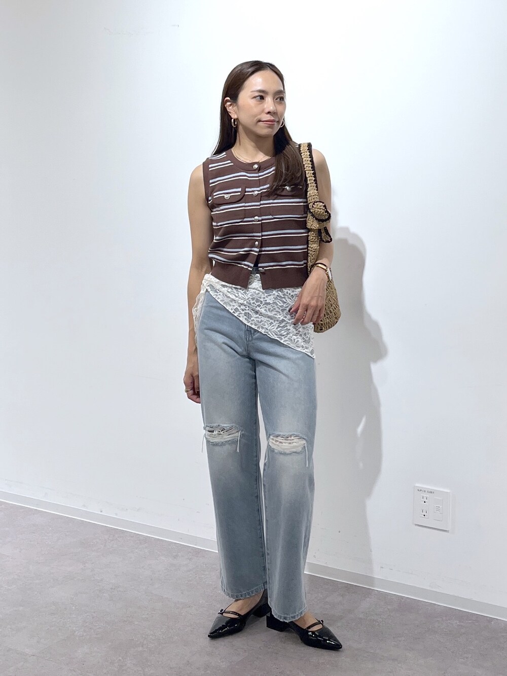 ブラウン系のニット/セーター、ブラック系のパンプス、ブルー系のデニムパンツを着用したレディースの夏コーディネートの9枚目の写真