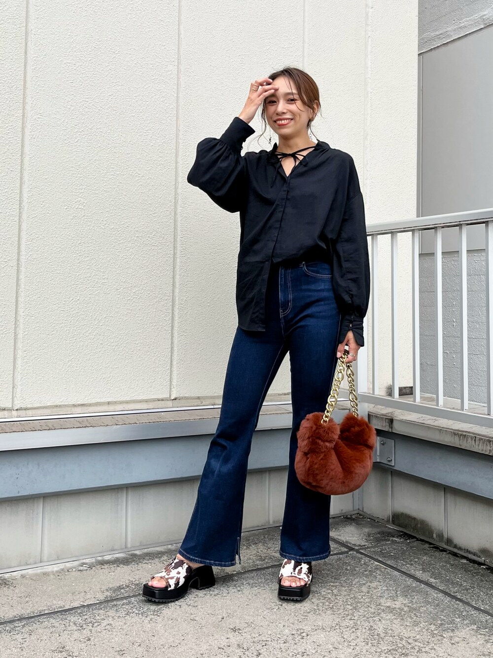 ブラック系のシャツ/ブラウス、ブラウン系のハンドバッグ、ホワイト系のサンダルを着用したレディースの秋コーディネートの2枚目の写真