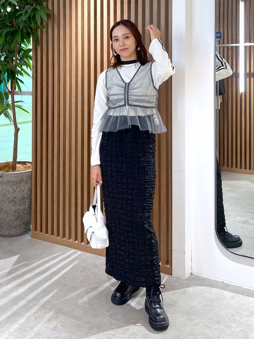 ホワイト系のTシャツ/カットソー、グレー系のシャツ/ブラウス、ブラック系のスカートを着用したレディースの秋コーディネートの2枚目の写真