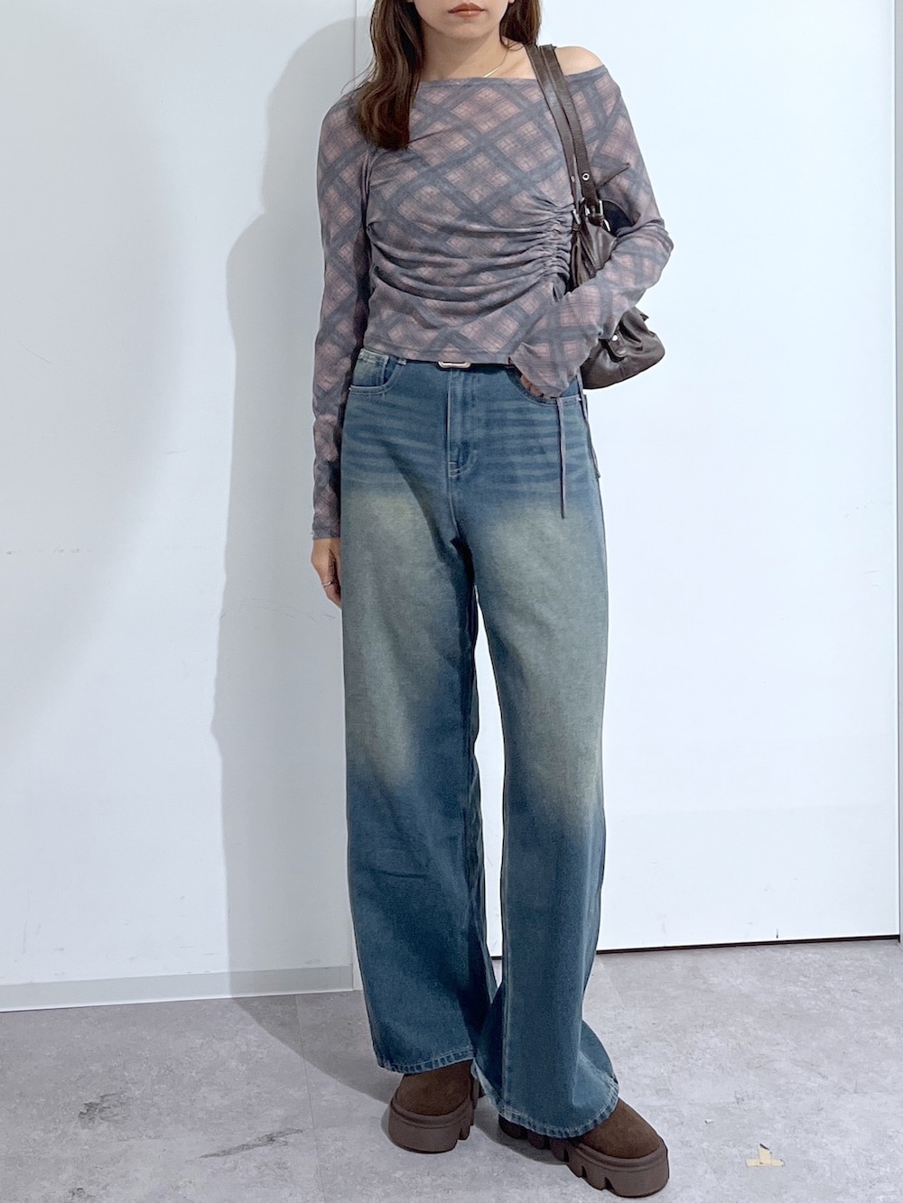 ブラウン系のショルダーバッグ、ブラウン系のTシャツ/カットソー、ブルー系のデニムパンツを着用したレディースの夏コーディネートの6枚目の写真