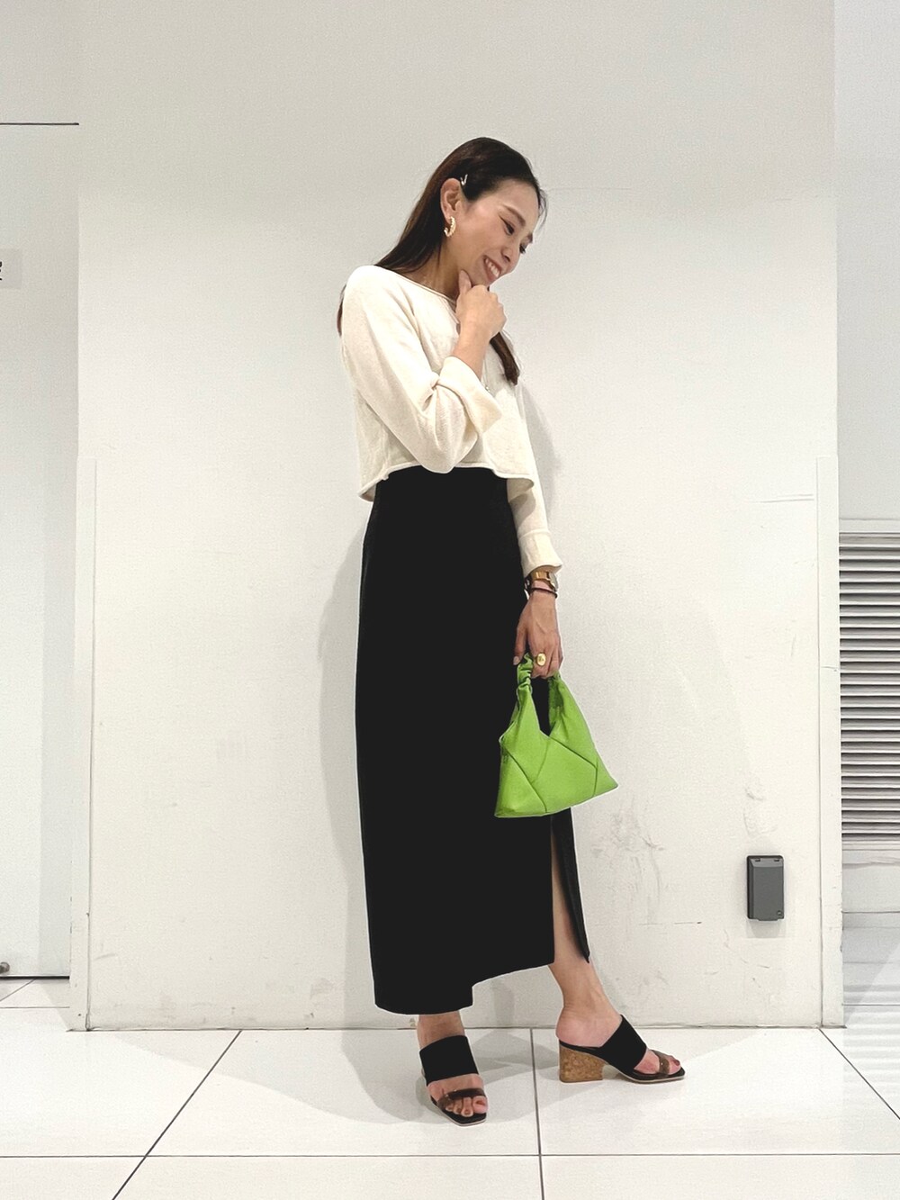 ホワイト系のニット/セーター、ブラック系のワンピース、ブラック系のサンダルを着用したレディースの春コーディネートの3枚目の写真