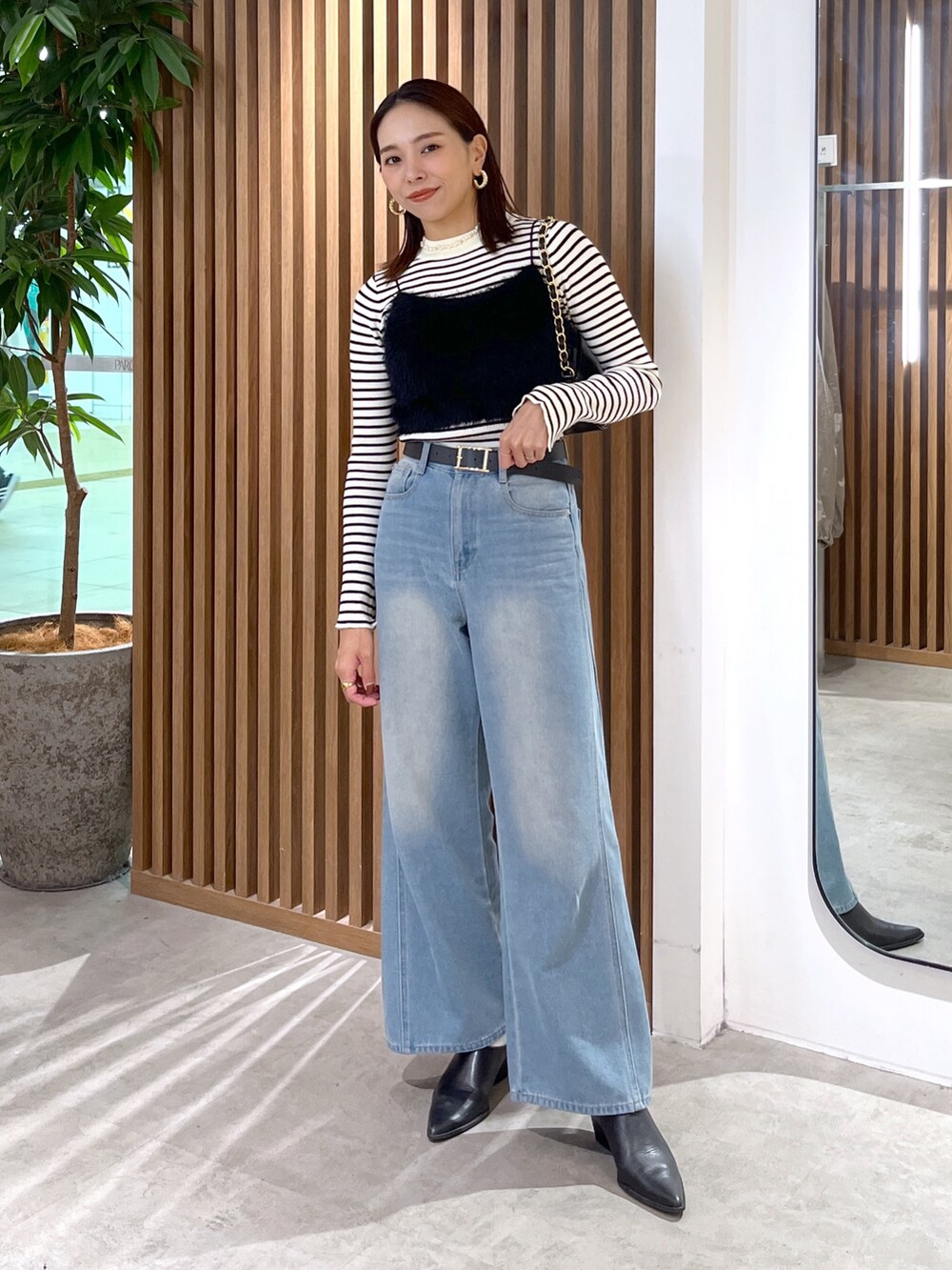 ブラック系のキャミソール、ホワイト系のニット/セーター、ブラック系のトートバッグを着用したレディースの秋コーディネートの9枚目の写真