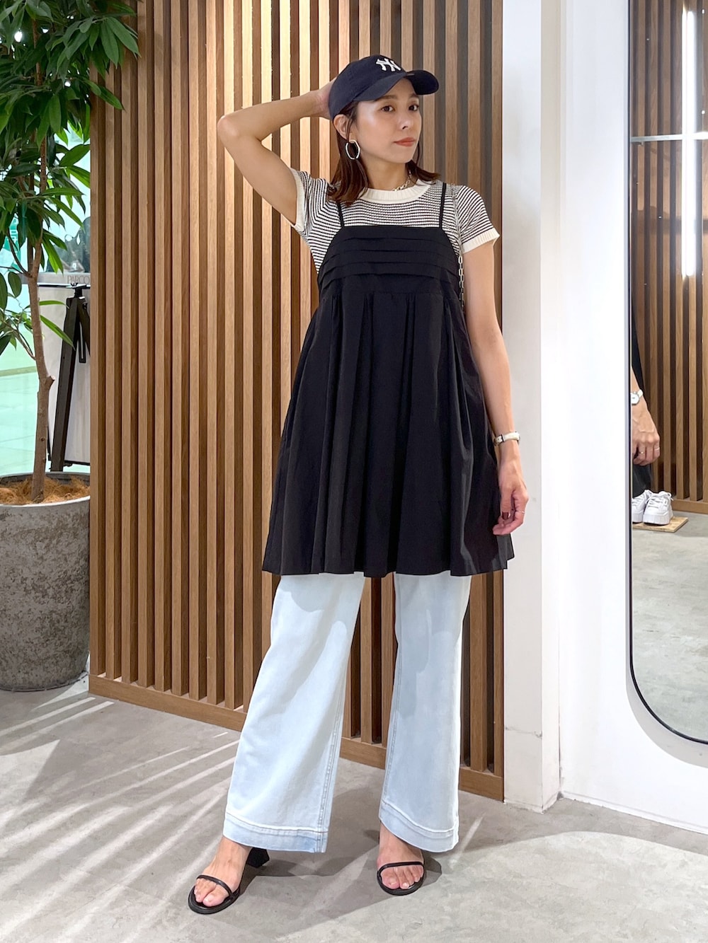 ブラック系のサンダル、ブルー系のデニムパンツ、ブラック系のワンピースを着用したレディースの夏コーディネートの9枚目の写真