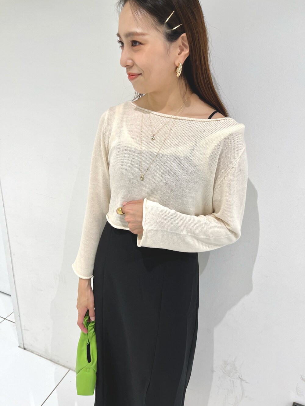 ホワイト系のニット/セーター、ブラック系のワンピース、ブラック系のサンダルを着用したレディースの春コーディネートの4枚目の写真