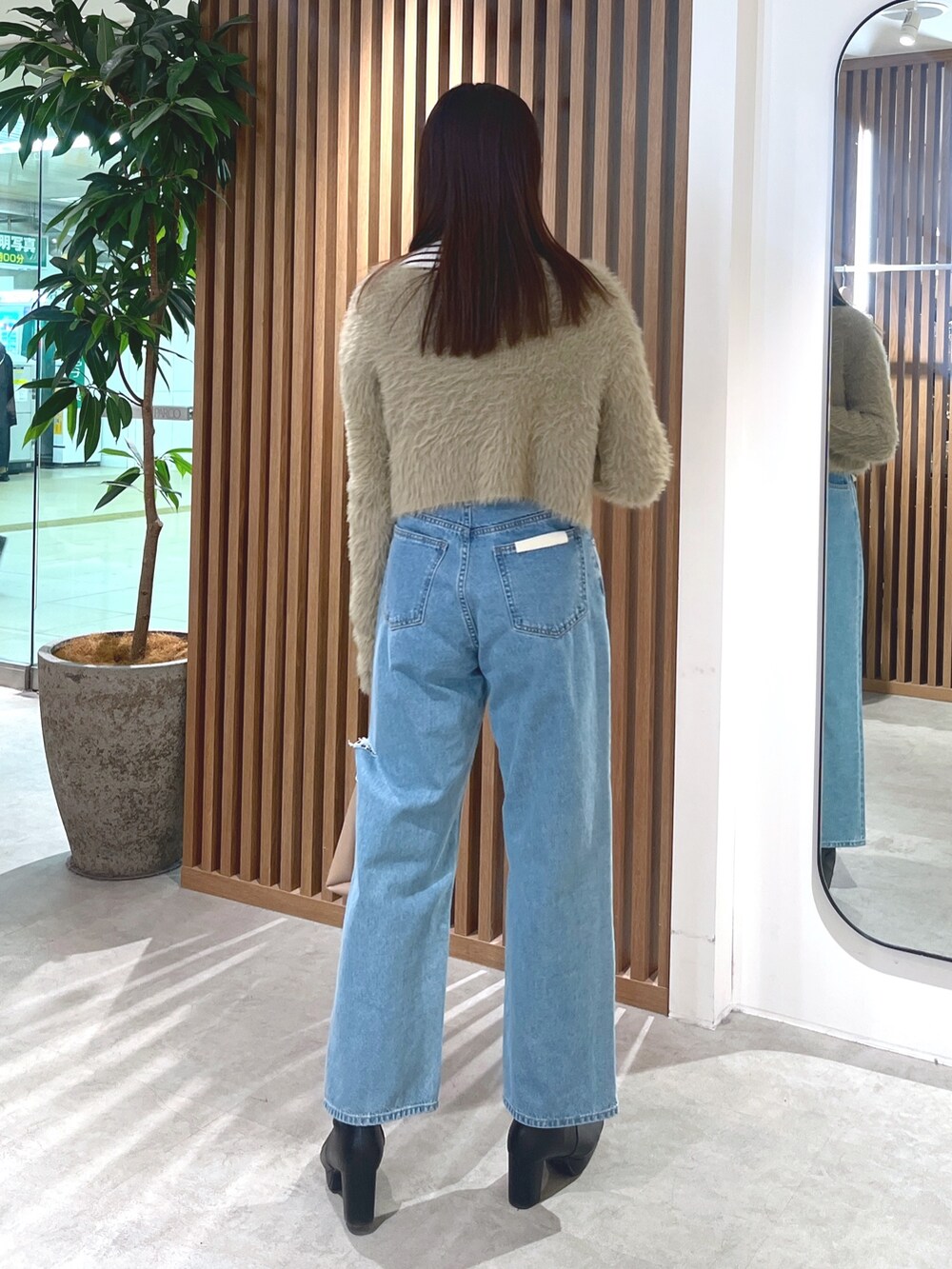 ベージュ系のカーディガン/ボレロ、ブルー系のデニムパンツ、ホワイト系のニット/セーターを着用したレディースの冬コーディネートの7枚目の写真