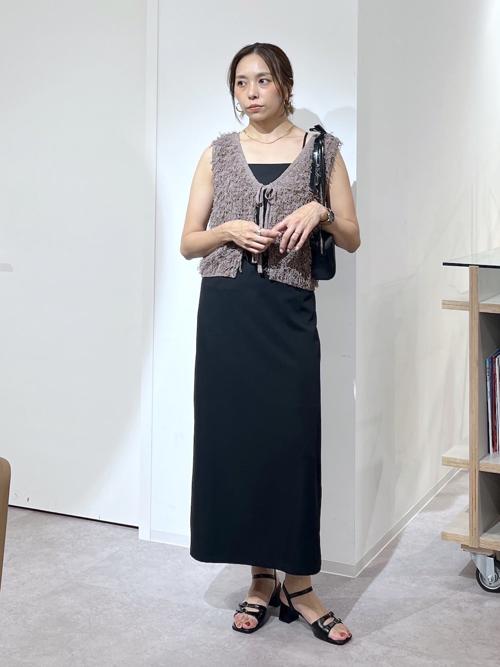 ブラック系のショルダーバッグ、ブラウン系のニット/セーター、ブラック系のワンピースを着用したレディースの夏コーディネートの9枚目の写真