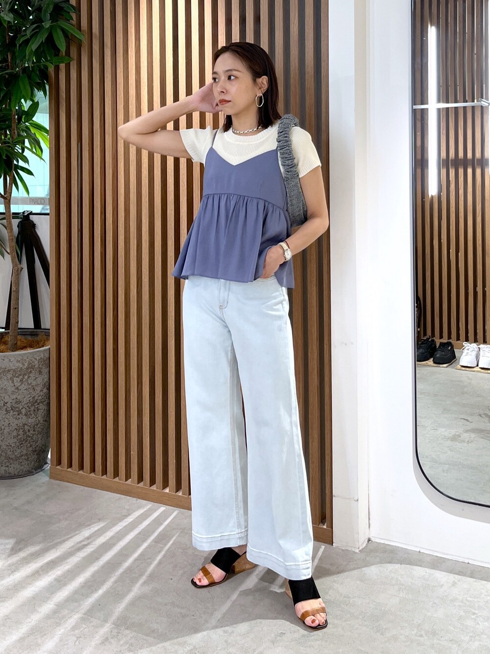 ホワイト系のニット/セーター、ブルー系のシャツ/ブラウス、ブルー系のデニムパンツを着用したレディースの夏コーディネートの7枚目の写真