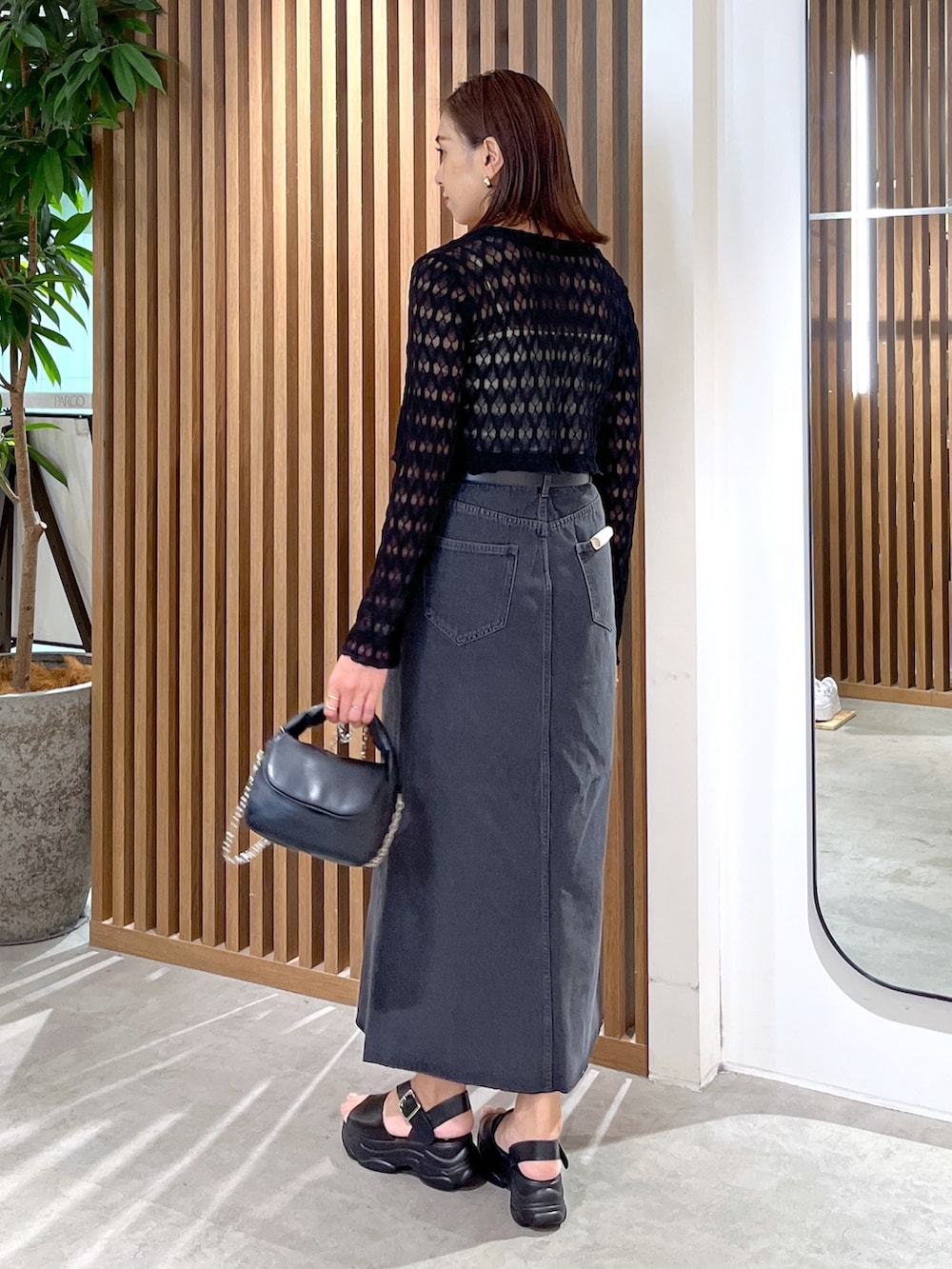 ブラック系のサンダル、ブラック系のショルダーバッグ、ホワイト系のキャミソールを着用したレディースの夏コーディネートの5枚目の写真