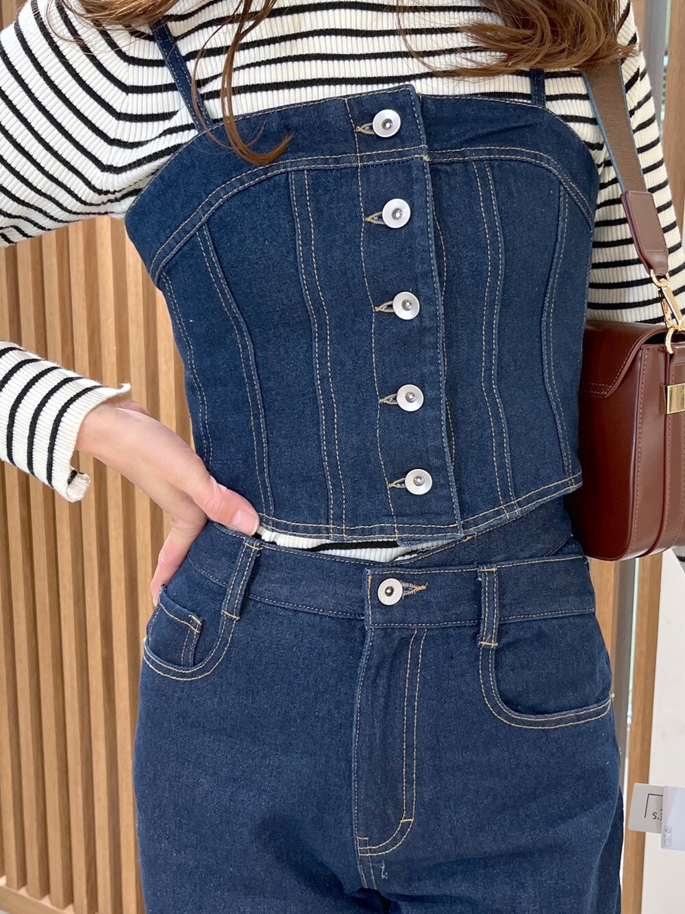 ブラック系のブーツ、ブルー系のデニムパンツ、ブラウン系のショルダーバッグを着用したレディースの冬コーディネートの5枚目の写真