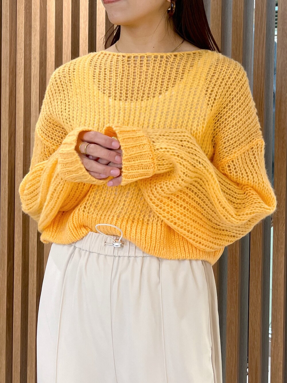 ホワイト系のショルダーバッグ、オレンジ系のニット/セーター、ホワイト系のその他パンツを着用したレディースの冬コーディネートの7枚目の写真