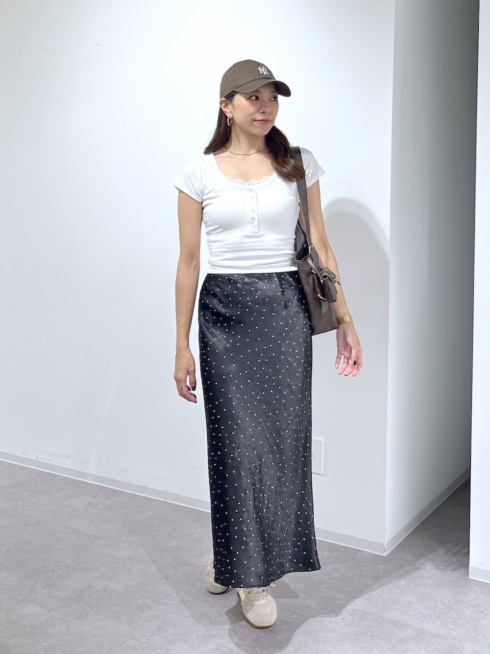 ホワイト系のTシャツ/カットソー、ブラウン系のショルダーバッグ、ブラック系のスカートを着用したレディースの夏コーディネートの2枚目の写真