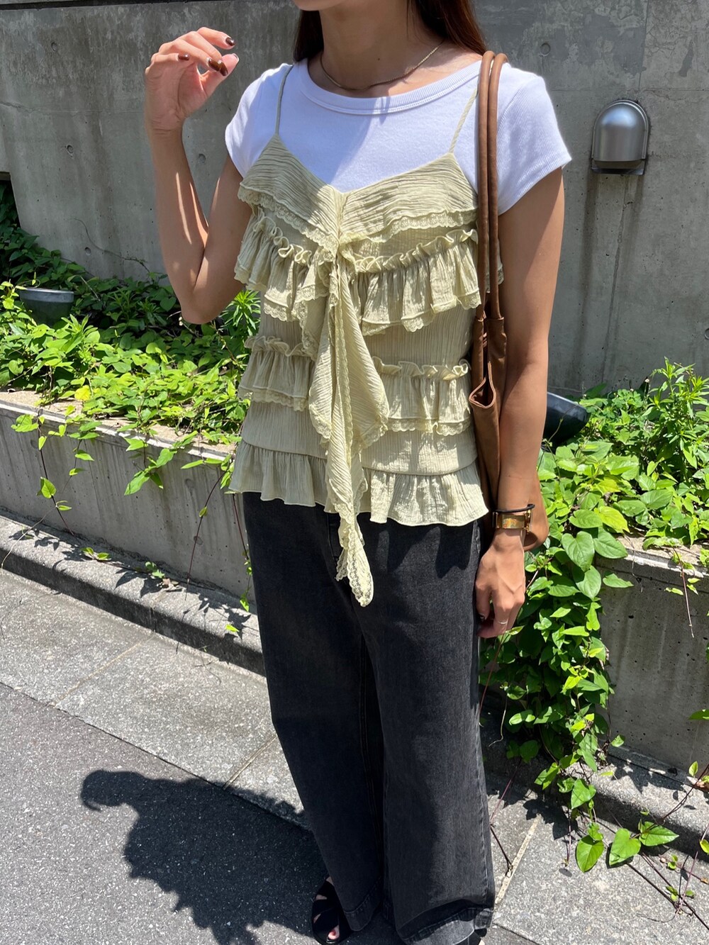 イエロー系のシャツ/ブラウス、ブラック系のデニムパンツ、ブラック系のサンダルを着用したレディースの夏コーディネートの6枚目の写真