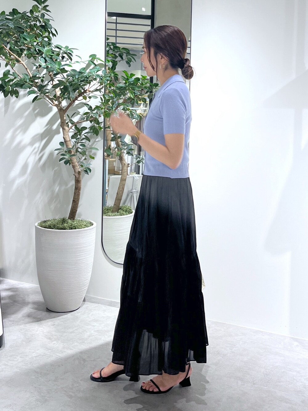 ホワイト系のトートバッグ、ブラック系のスカート、ブルー系のニット/セーターを着用したレディースの夏コーディネートの4枚目の写真