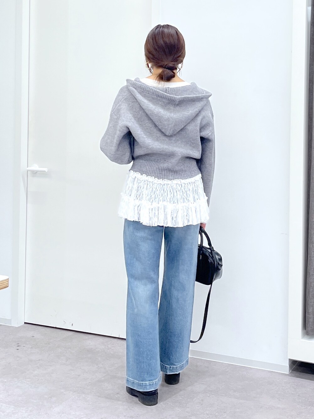 ブラック系のショルダーバッグ、ブルー系のデニムパンツ、ホワイト系のTシャツ/カットソーを着用したレディースの冬コーディネートの7枚目の写真