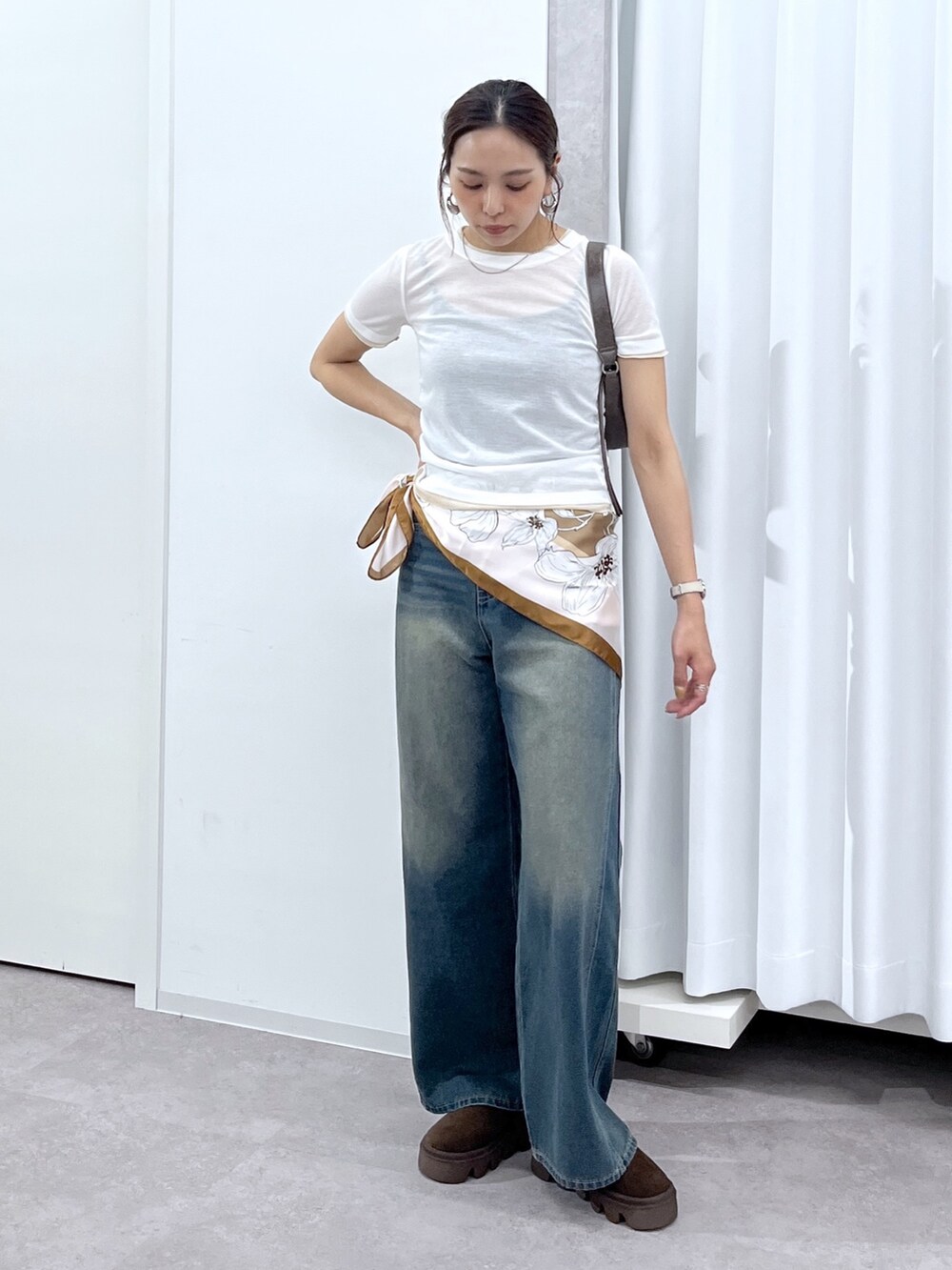 ホワイト系のTシャツ/カットソー、ブラウン系のショルダーバッグ、ブルー系のデニムパンツを着用したレディースの春コーディネートの8枚目の写真